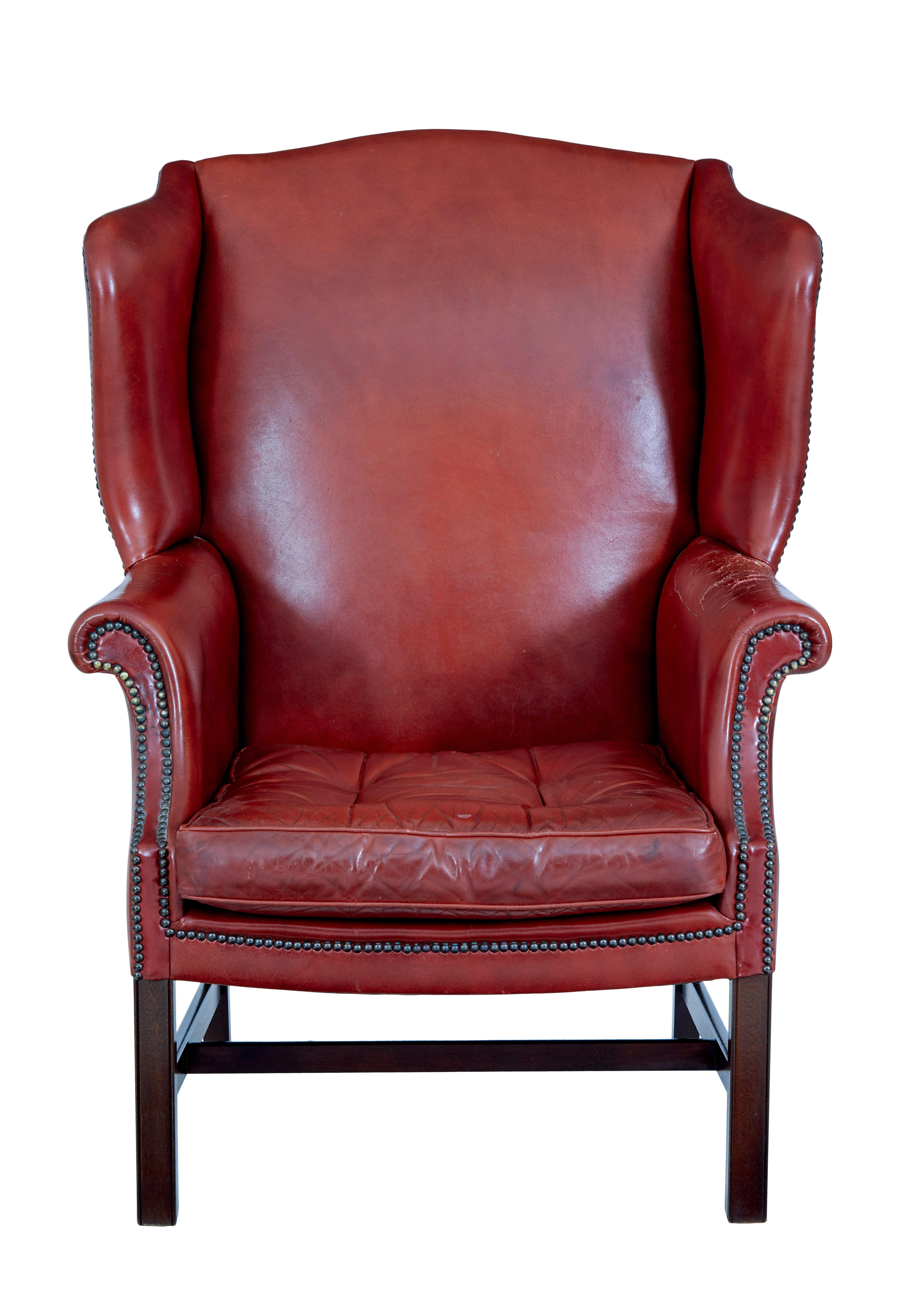 Sillón con respaldo de cuero de mediados del siglo XX, hacia 1950.

Grandes proporciones en este sillón de cuero con respaldo de ala.  Color rojo intenso con tachuelas en el brazo, cojín de asiento extraíble con botones y ribete.

De pie sobre un