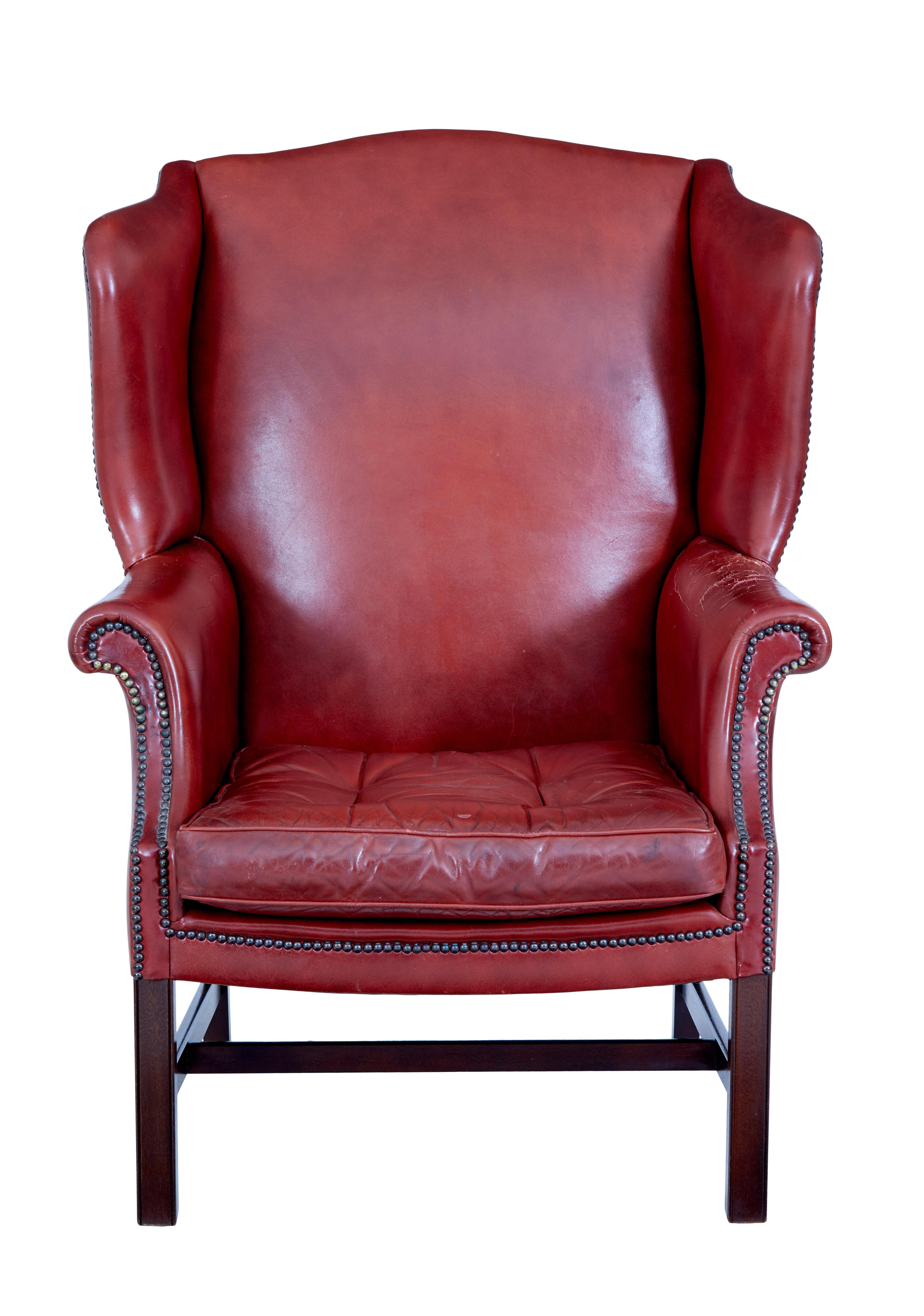 Mid 20th century leather wingback armchair circa 1950.

Great proportions on this leather wingback chair.  Deep red colour with studwork to the arm, removable seat cushion with buttons and piping.

Standing on a mahogany frame.

Obvious wear to 1