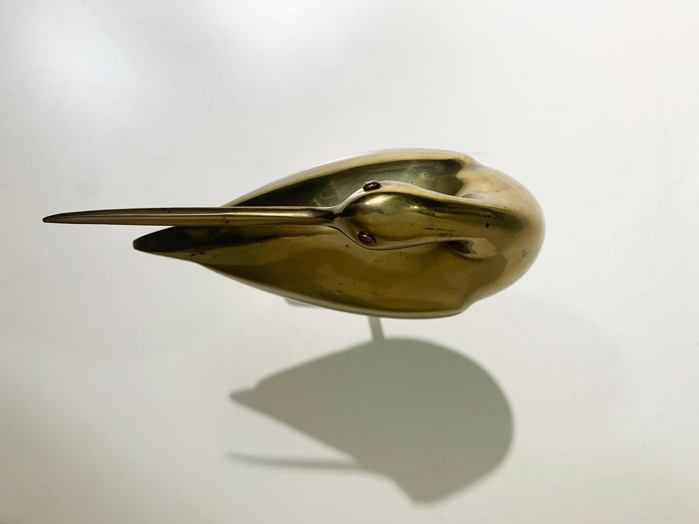 Elevate your space with this elegant Mid 20th Century Long-Billed Curlew Bird Statue, crafted in brass and dating from the 1970s. 
The statue captures the graceful form of the curlew with its distinctive long bill and sleek, slender body, embodying