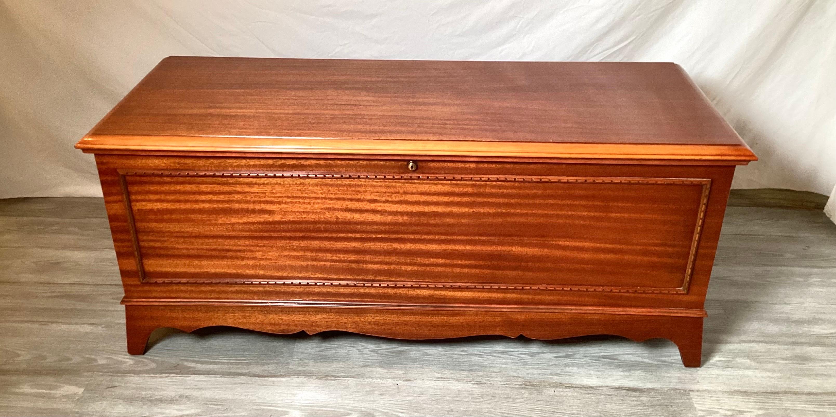 Chic and functional mid 20th century medium color mahogany chest with cedar wood lining. The chest, made by Lane is in near perfect condition with a lock, key and all original documentation. Made in 1951.