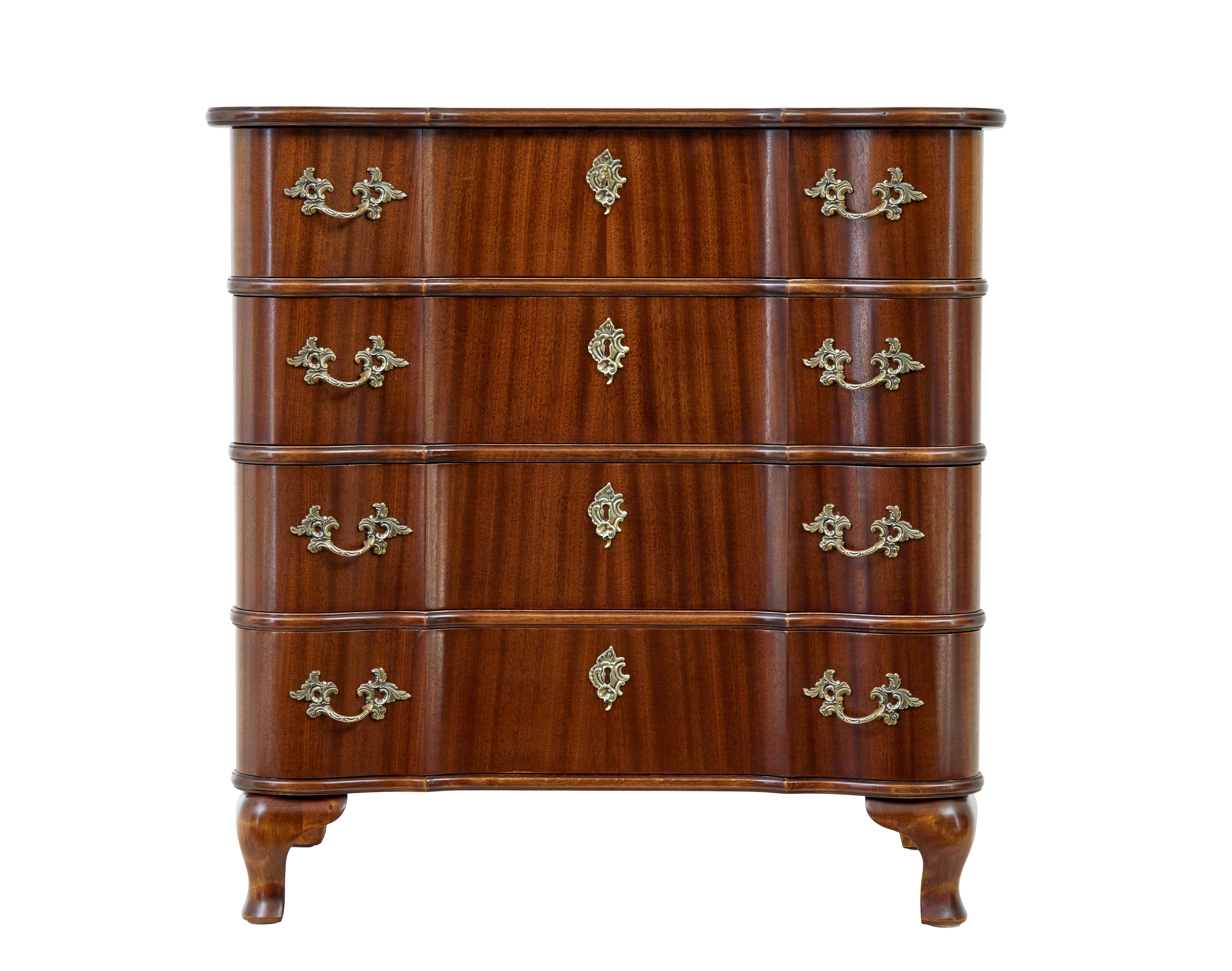 Commodo in mogano di ispirazione barocca della metà del XX secolo, circa 1950.

Cassettone in mogano di produzione danese con cassetti sagomati di gusto barocco.  4 cassetti con piastre ornamentali in ottone ed escutheon.  In piedi su piedi ogivali
