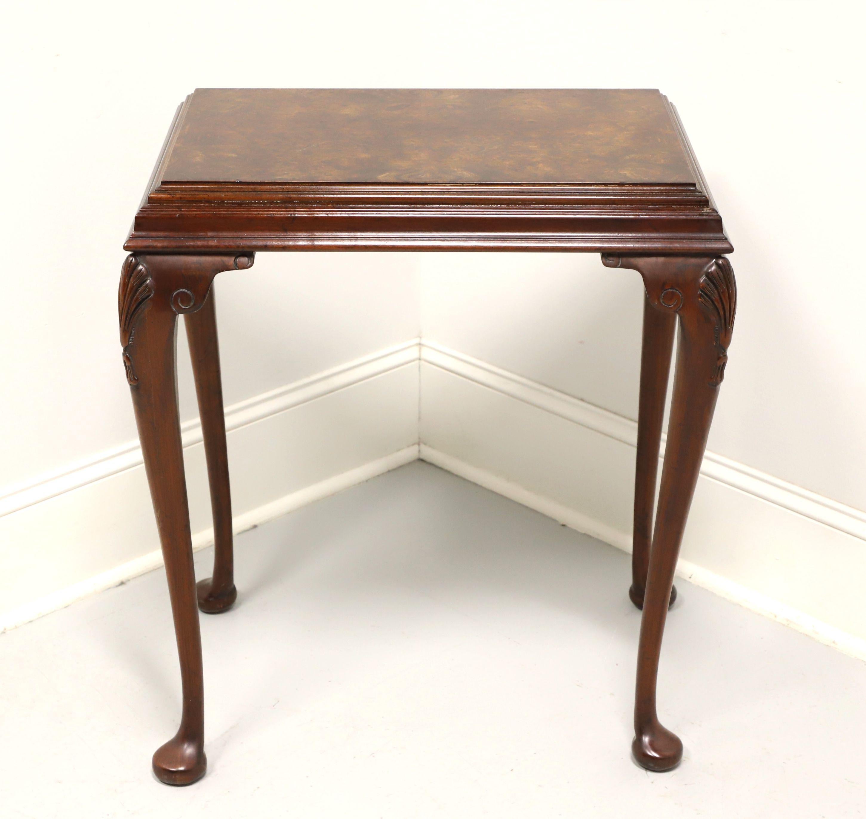 A Queen Anne style side table, unbranded, similar quality to Hekman. Mahogany with inlaid burlwood top, tiered sides, fan carved knees, cabriole legs and pad feet. Features the inlaid burlwood top and tiered sides providing a layered design. Likely