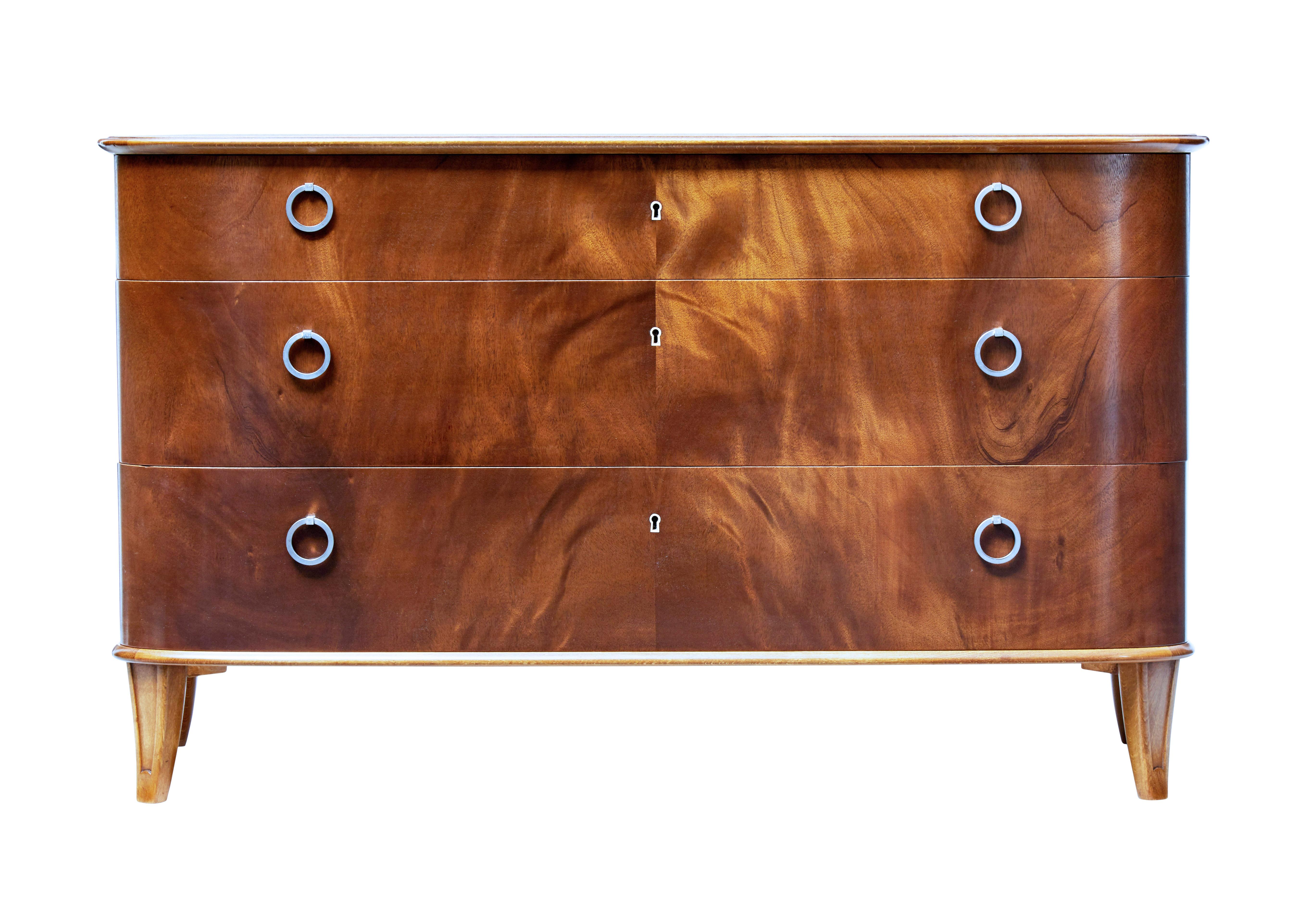 Mid-20th century mahogany chest of drawers Svensk Mobelindustri, circa 1950.

Fine quality shaped chest of drawers by Swedish retailers Svensk Mobelindustri.

Presented in excellent condition. 3 graduating drawers with matched flame mahogany
