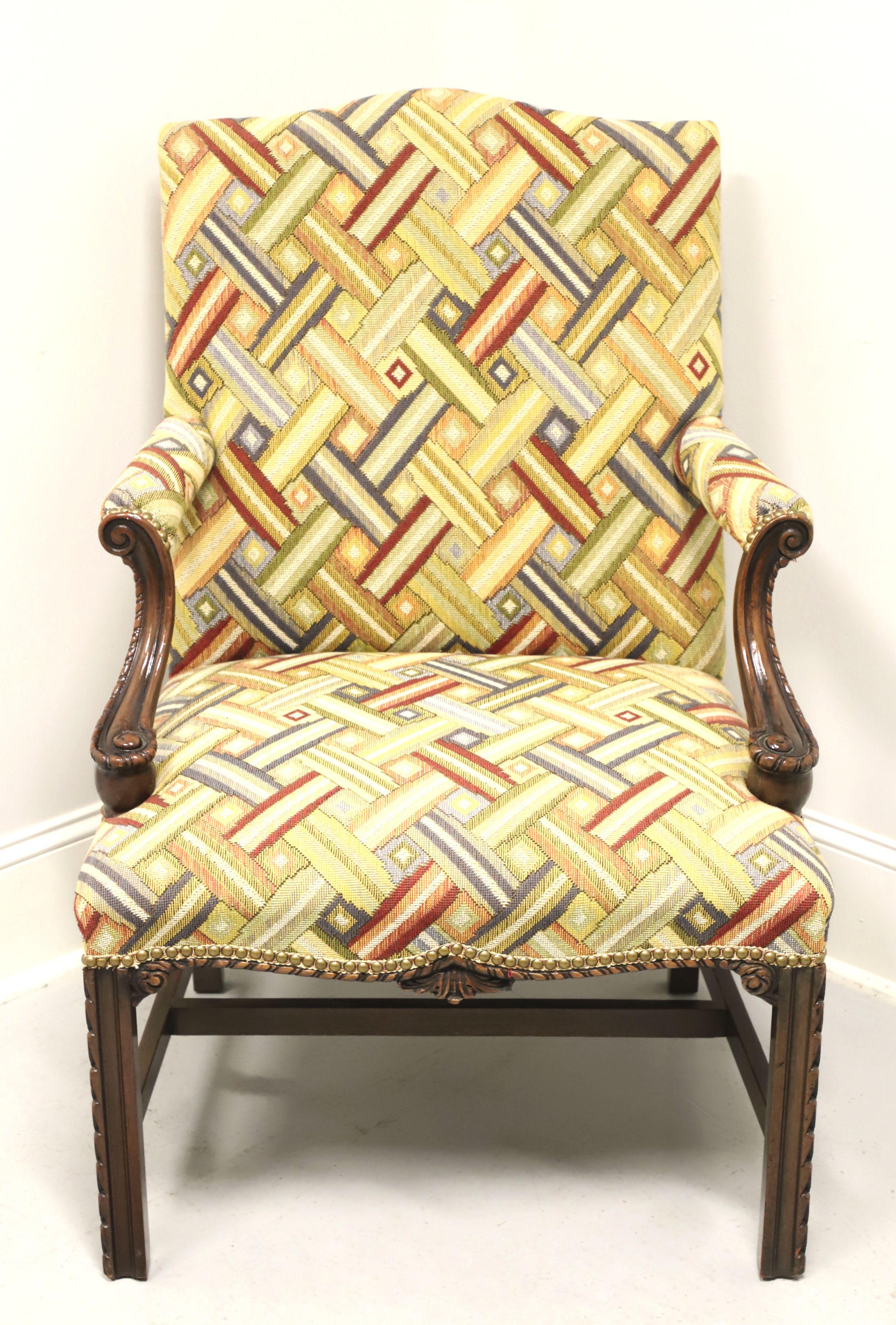 A Chippendale Martha Washington style upholstered armchair, unbranded, similar quality to Drexel or Hickory Chair. Mahogany frame, multi-colored interwoven pattern fabric upholstery, high back, upholstered arms with carved mahogany supports, brass