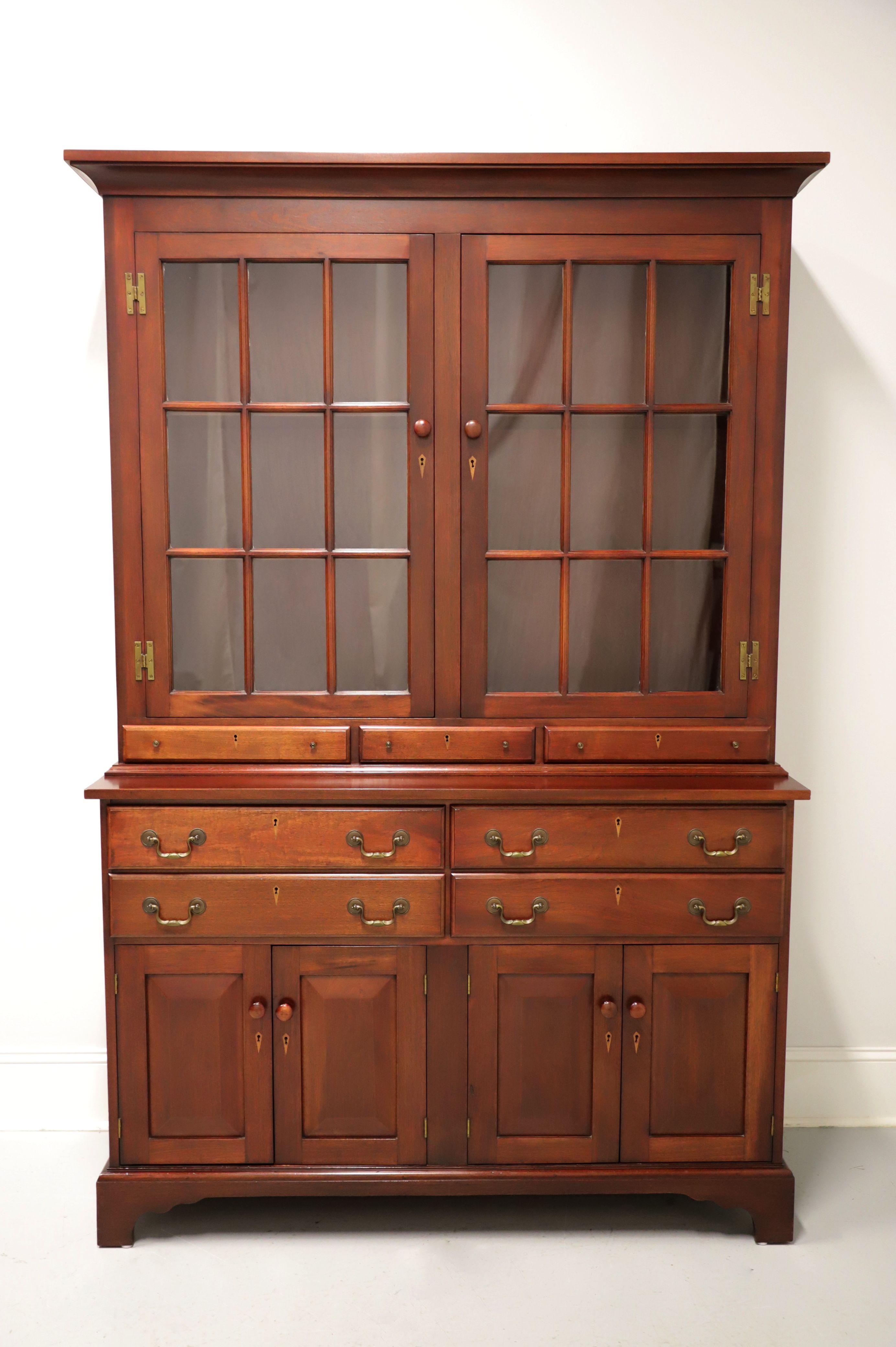 A Colonial style china cabinet hutch, no branding marks found, attributed to Benbow's. Solid mahogany with brass hardware, crown molding, and bracket feet. Upper cabinet features dual nine-paned glass doors with wood knobs revealing two fixed wood
