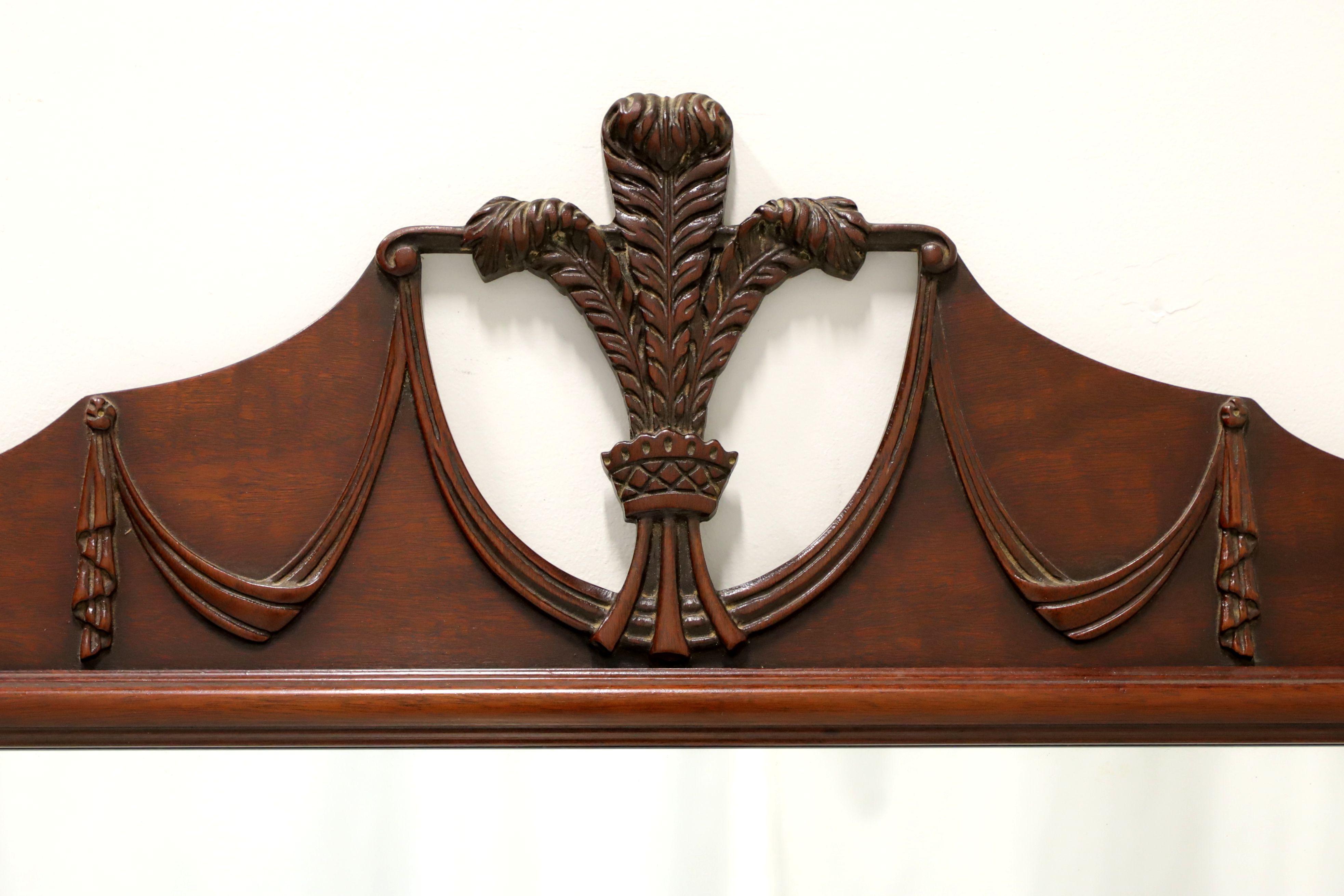 A Traditional style wall mirror, unbranded. Mirror glass in a solid mahogany frame with decoratively carved Prince of Wales plumes to top center & drapery swags and a carved bottom. Made in the USA, in the mid 20th Century.

Measures: 50w 1.25d