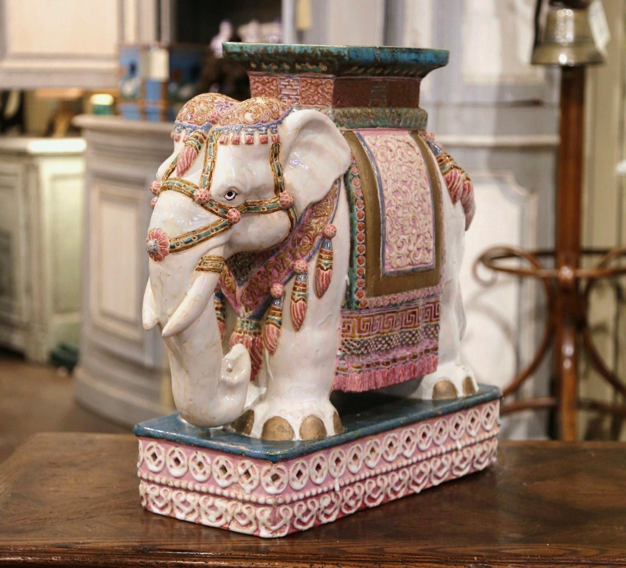 Crafted in Malaysia circa 1960, the ceramic seating is in the shape of an elephant, and heavily decorated in oriental finery. The mammal has a rectangular seat at the top, and is hand painted in the beige, white and green palette. This unique figure