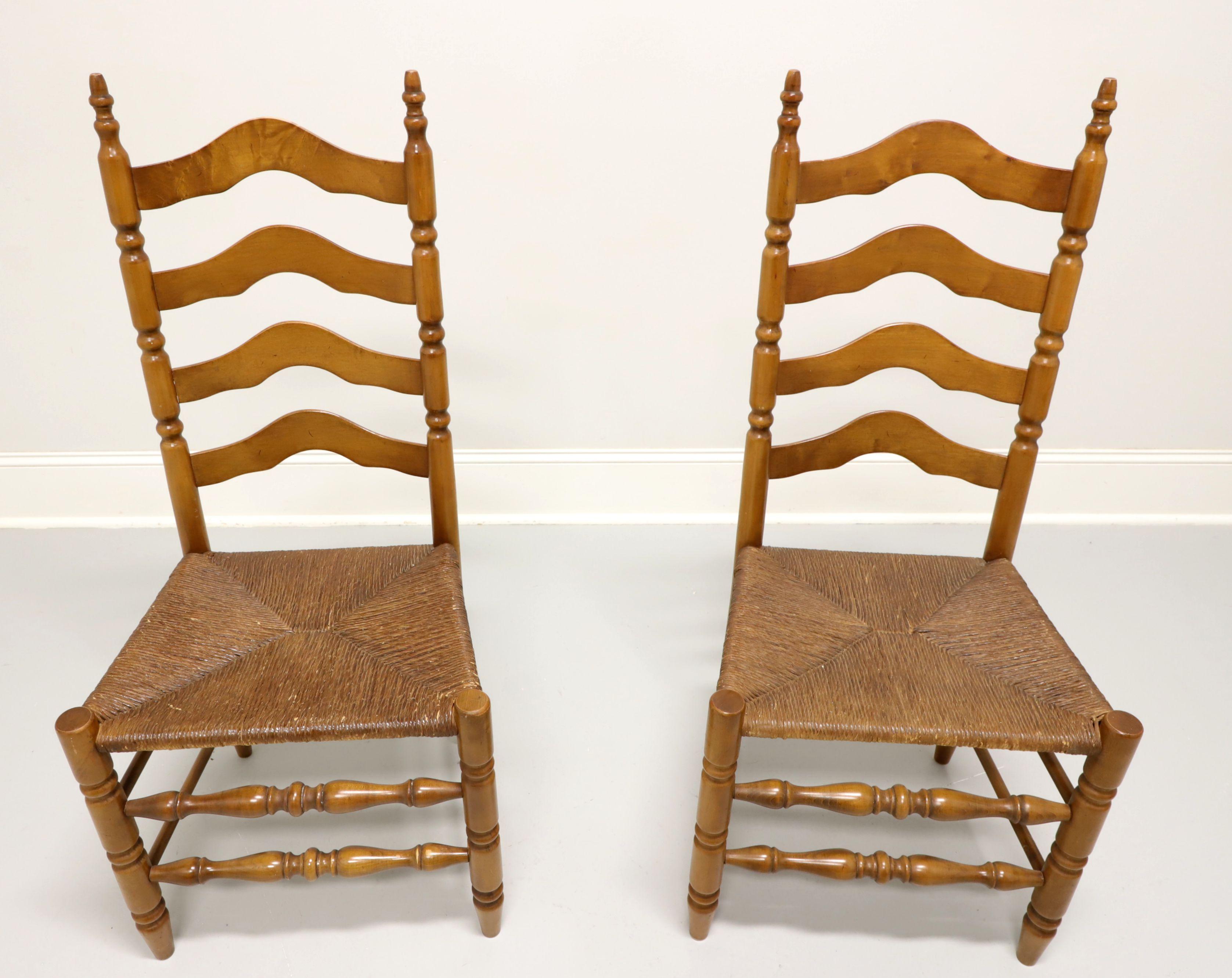 A pair of Cottage / Farmhouse style dining side chairs, unbranded, similar in quality to Ethan Allen. Maple with carved arched ladder back design, rush seats, turned front legs & front stretchers, and solid back legs & back/side stretchers. Made in