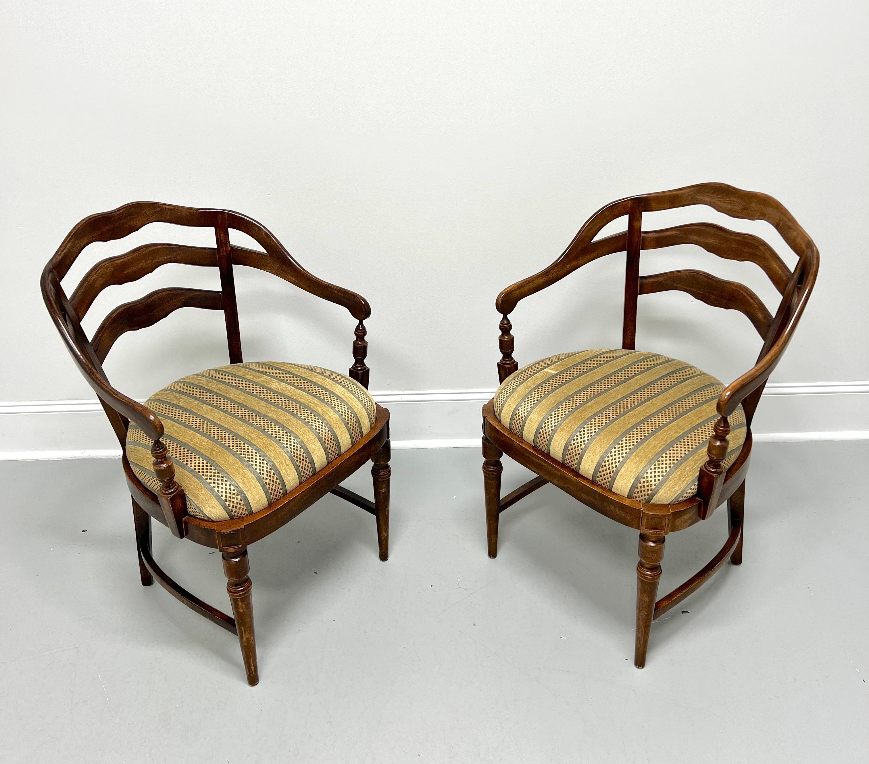 A pair of French Country style barrel chairs, unbranded. Maple with a lightly distressed finish, ladder back design, curved crest rail, curved arms with turned supports, gold tones color stripe fabric upholstered seat, solid apron, side stretchers,