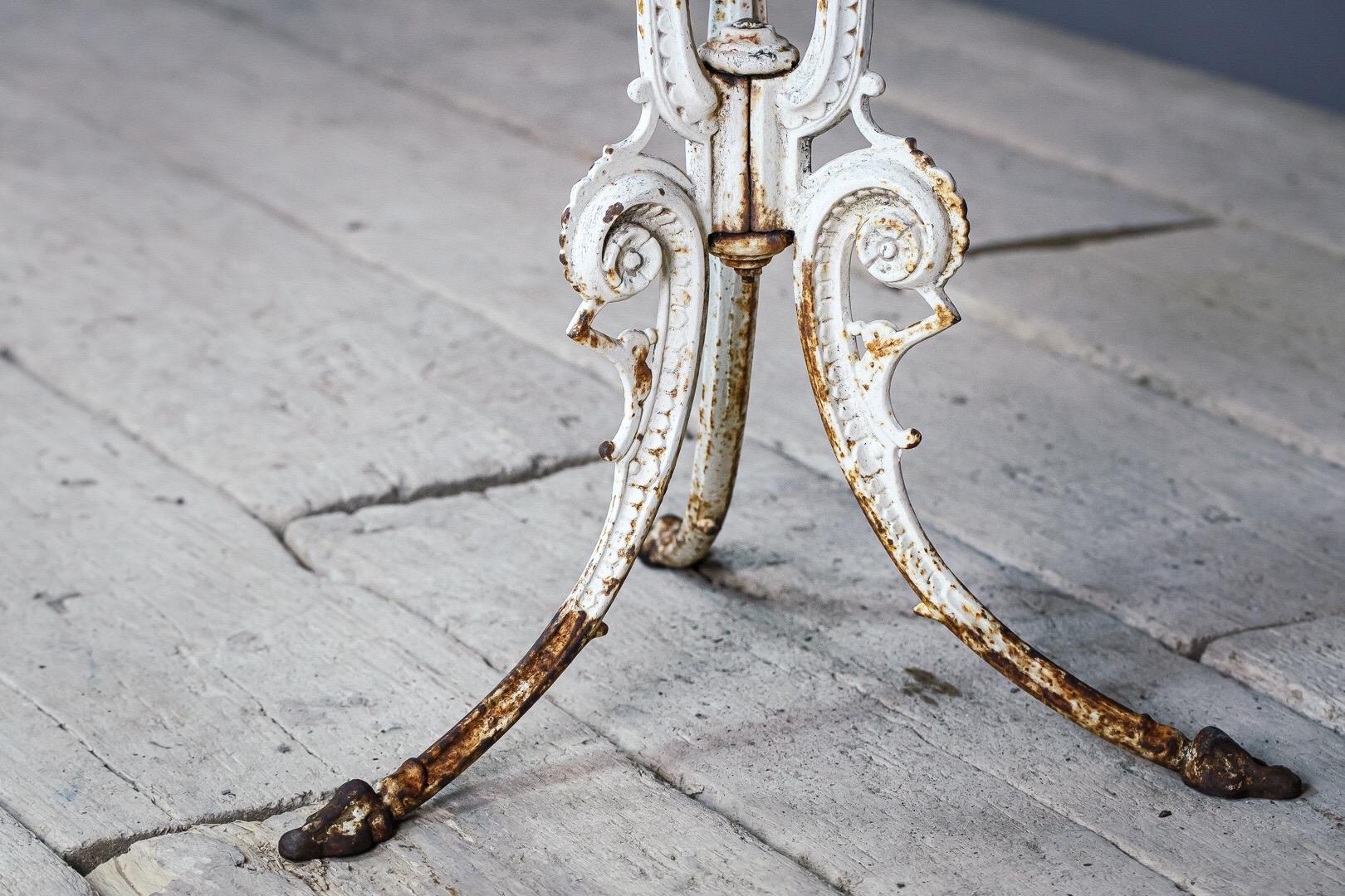 Iron and marble bistro table. Decorative delicate cast iron base, wonderfully shaped and weathered marble top.