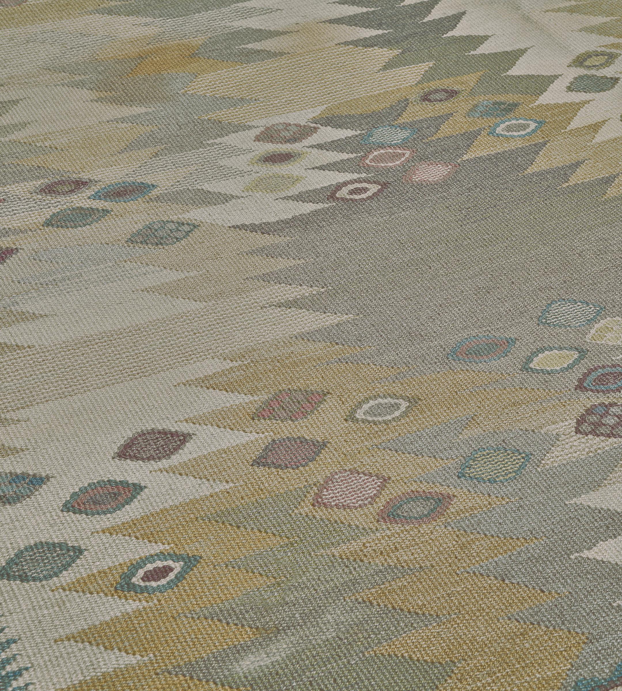 Dieser handgewebte schwedische Teppich im Vintage-Stil hat ein tonales Gesamtfeld aus Kamel-, Beige-, Salbei- und Grautönen, in das ein gezacktes geometrisches Motiv eingewoben ist, das von polychromen, verstreuten Rautenreihen überlagert wird.
