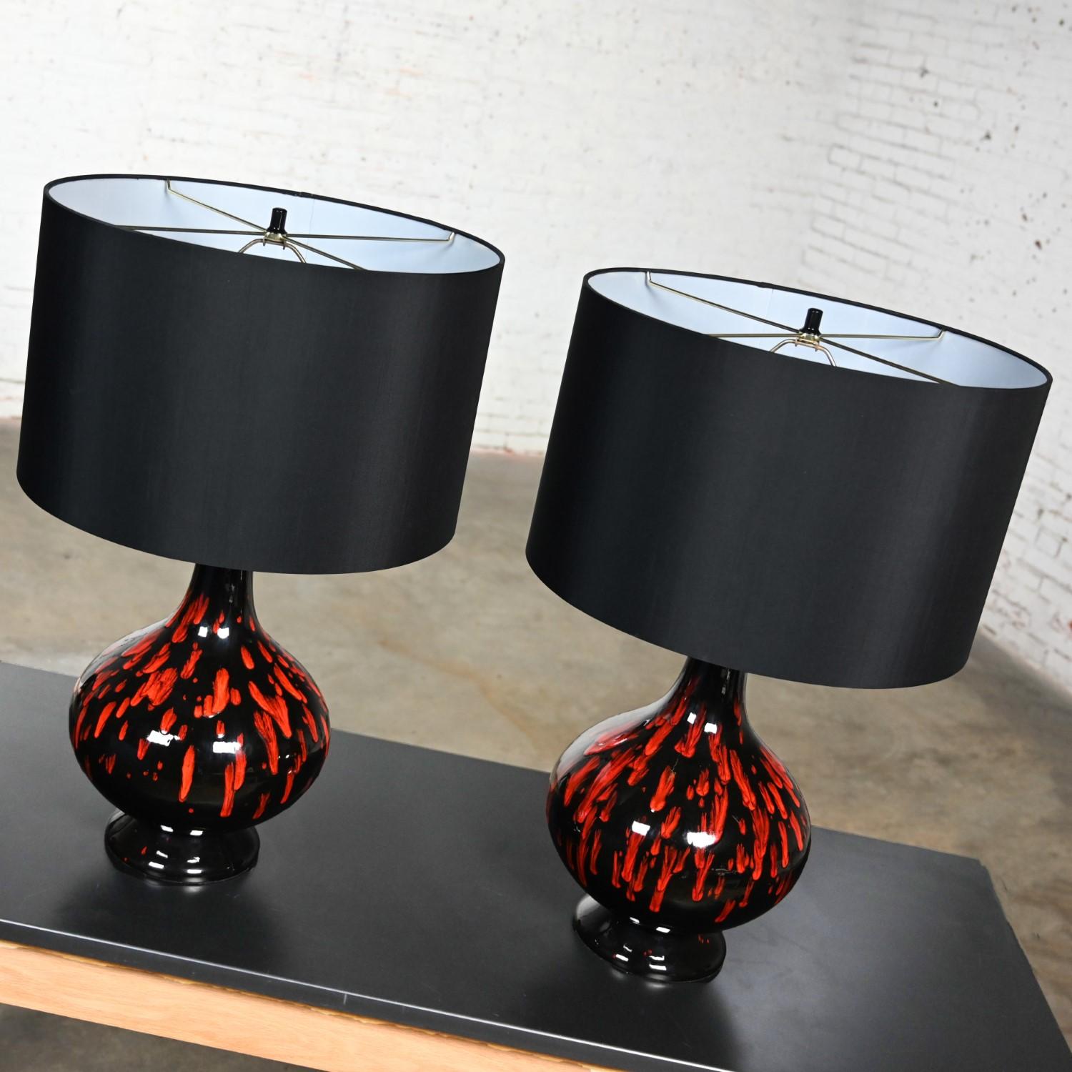 Gorgeous vintage Mid-Century Modern ceramic orange & black glossy drip glaze table lamps with new black linen-like drum shades, a pair. Beautiful condition, keeping in mind that these are vintage and not new so will have signs of use and wear even