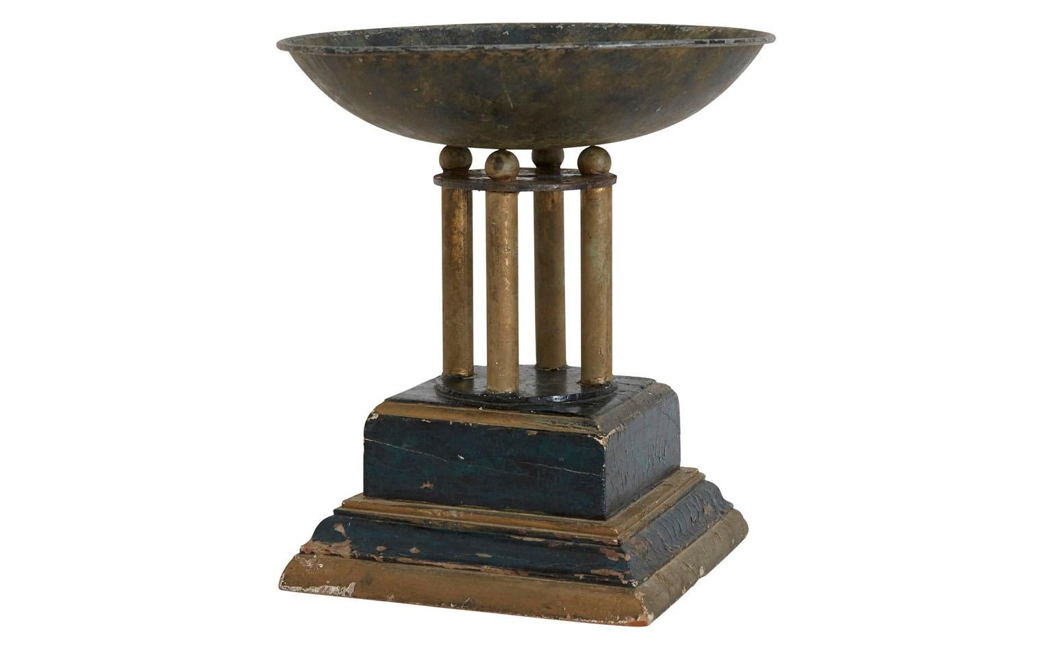 Found in America, our Vintage Pedestal Bowl dates back to the mid-20th century. It features a shallow metal bowl which balances on four matching metal rods and its original, weathered wood-painted base. This curious vessel is in good condition for