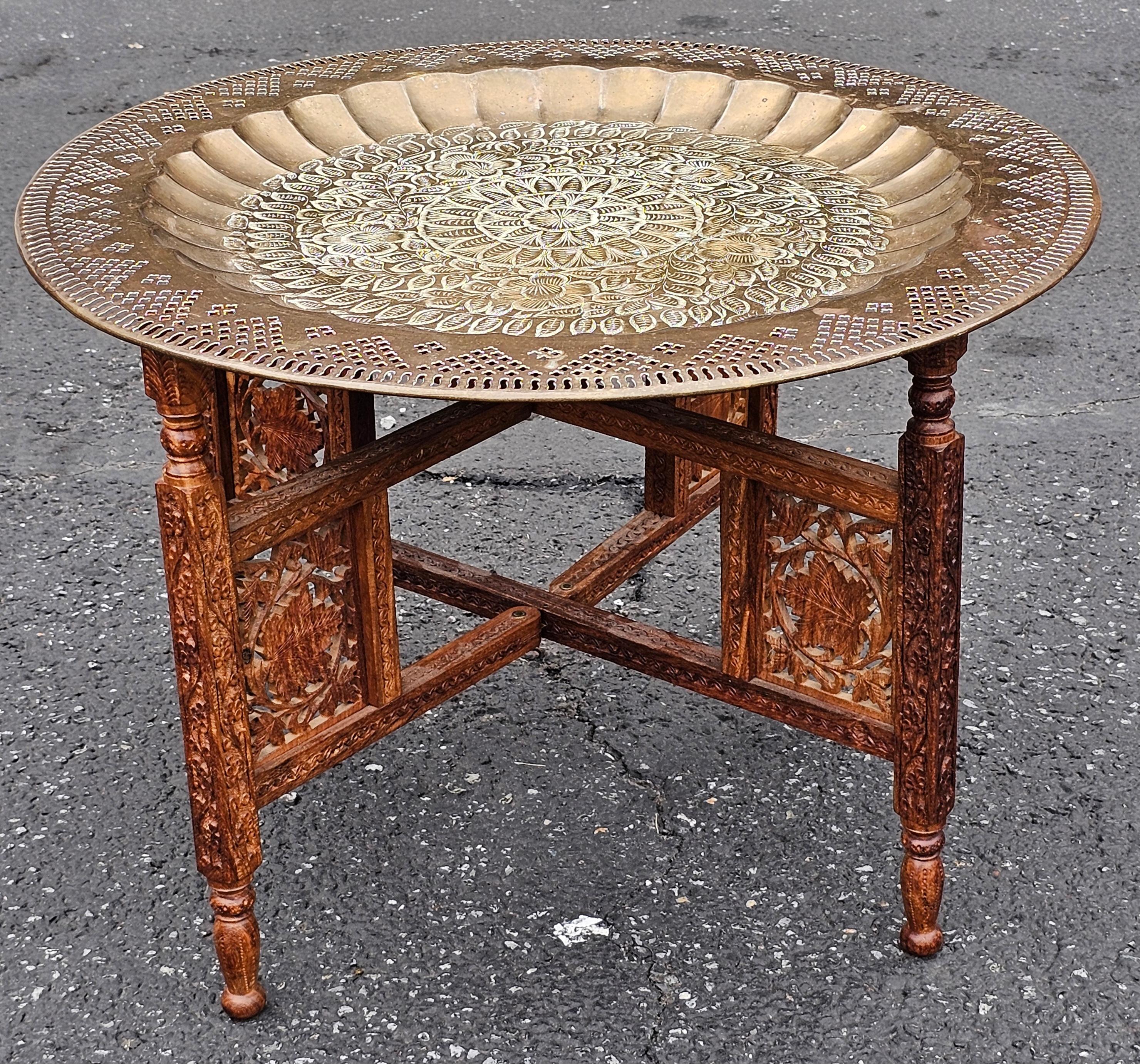 A Mid 20th Century Middle Eastern Carved Teak and Etched Brass Folding Tray Table.
Measure 23