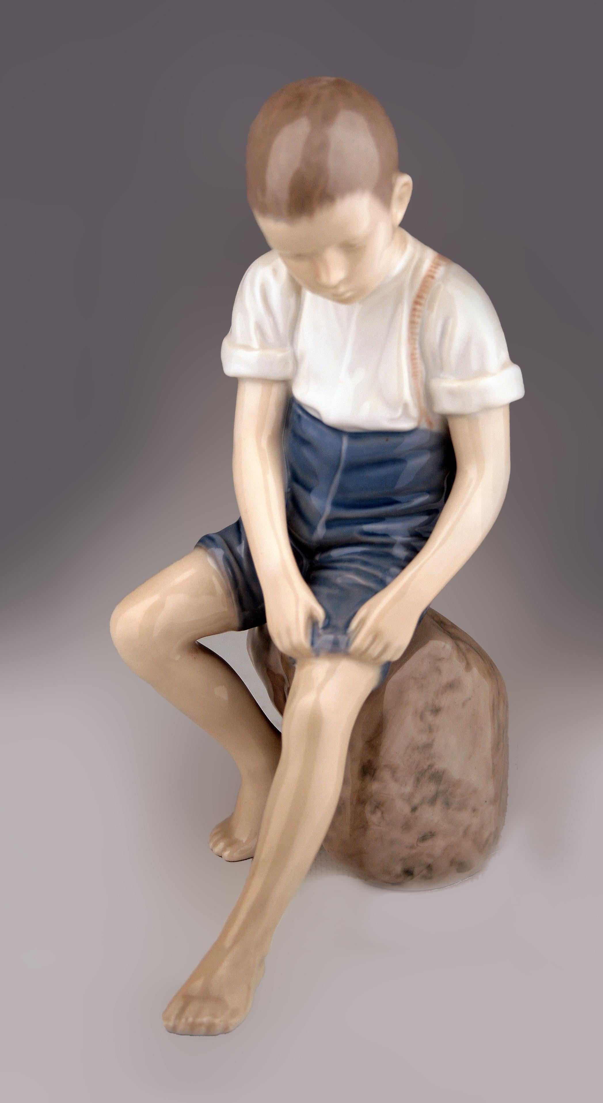 Mitte des 20. Jahrhunderts skandinavische moderne glasierte Porzellanskulptur eines auf einem Felsen sitzenden Jungen der dänischen Firma Bing & Grøndahl

von: Bing & Grøndahl
MATERIAL: Porzellan, Farbe, Keramik
Technik: gepresst, geformt,