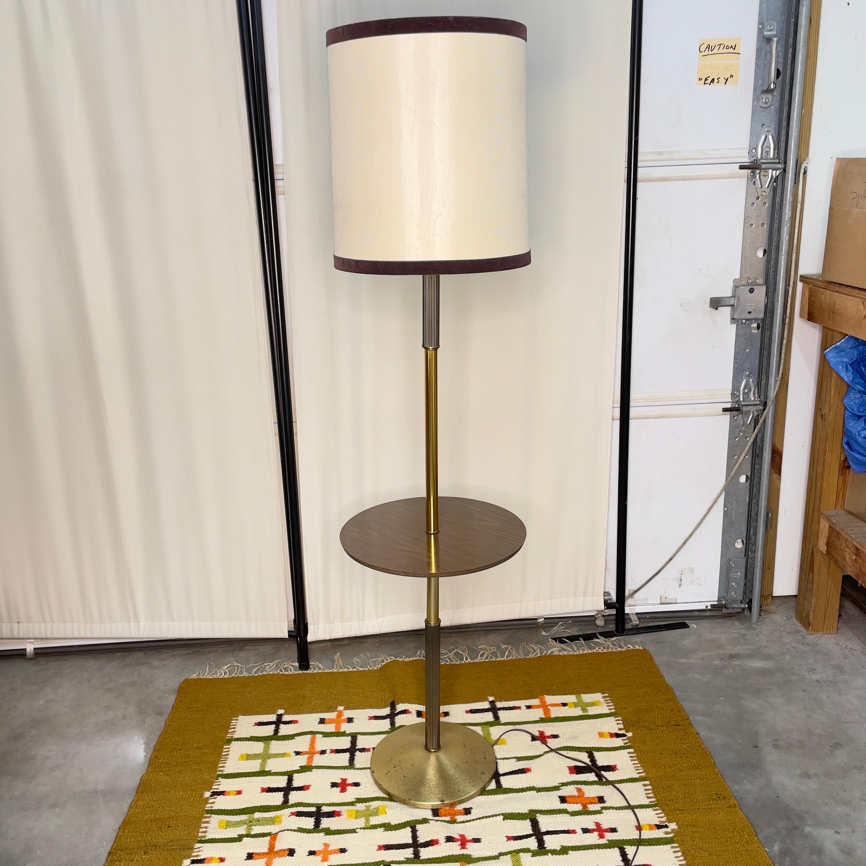 Mid century modern floor lamp with table attached mid way on the lamp. Includes the original shade which is in good condition. Original plug in working condition. Laminate table top which means you don’t have to worry about water rings!