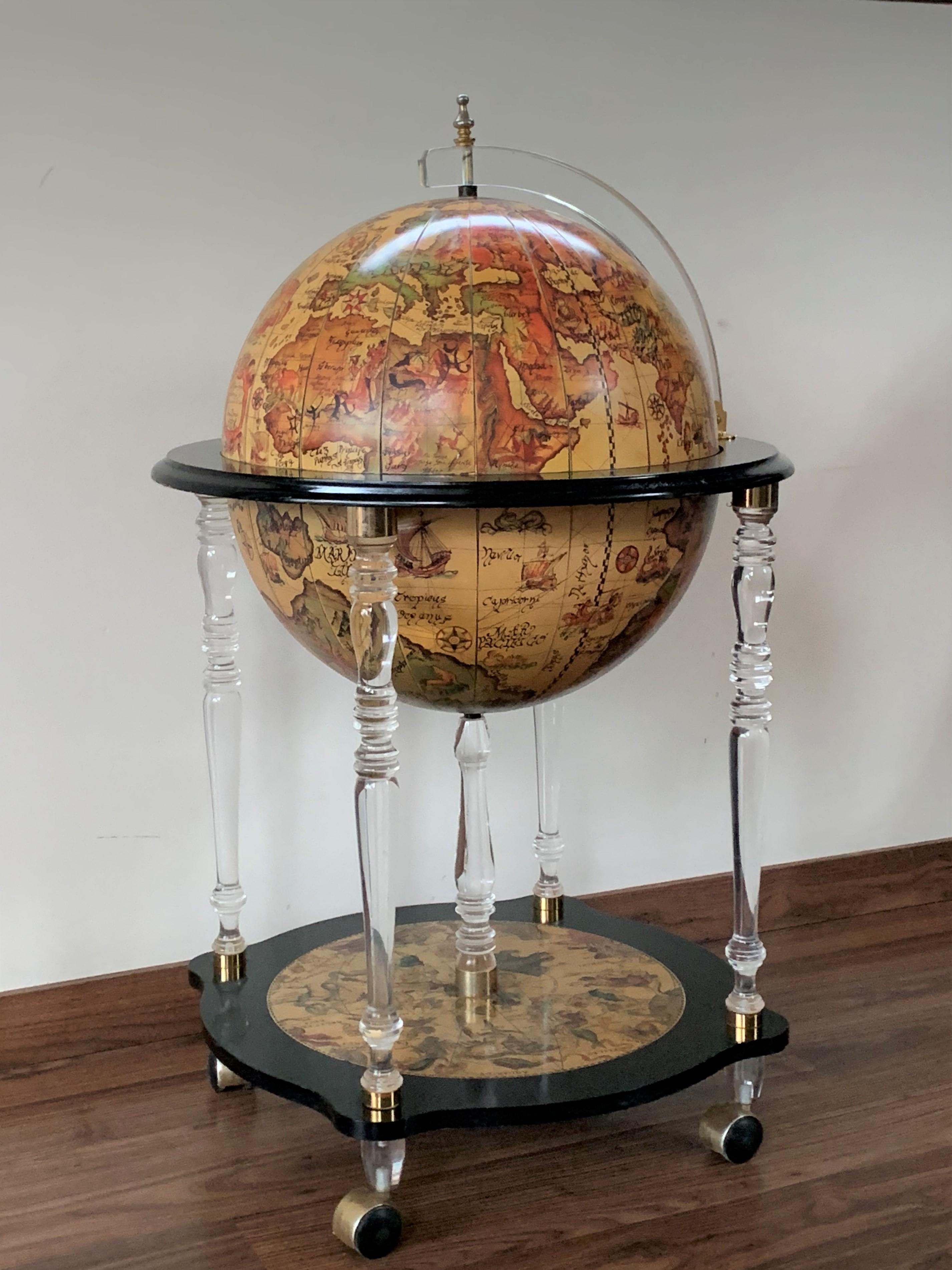 This is a modernist midcentury cocktail drinks cabinet in the form of a globe, circa 1950 in date.

The hinged top section opens to reveal a fitted interior with spaces for glasses and an ice bucket.

The exterior of the globe has the map of the