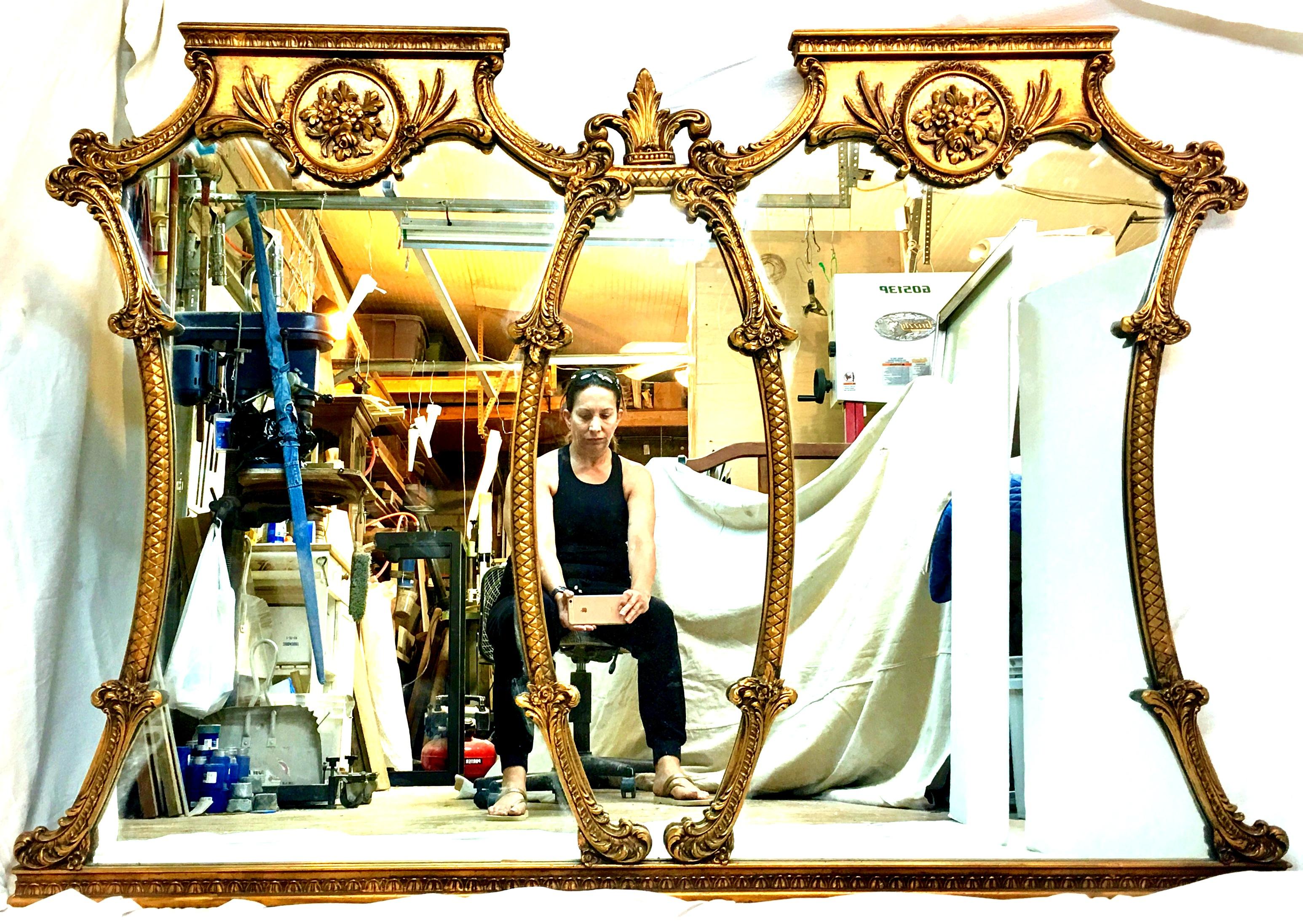 Mid-20th Century Monumental Stunning & Ornate French style carved gilt wood triptych large wall mirror. Measuring at 5.5 feet in length, this large three section hand carved gilt wood mirror 
features a classic and timeless floral, acanthus leaf and