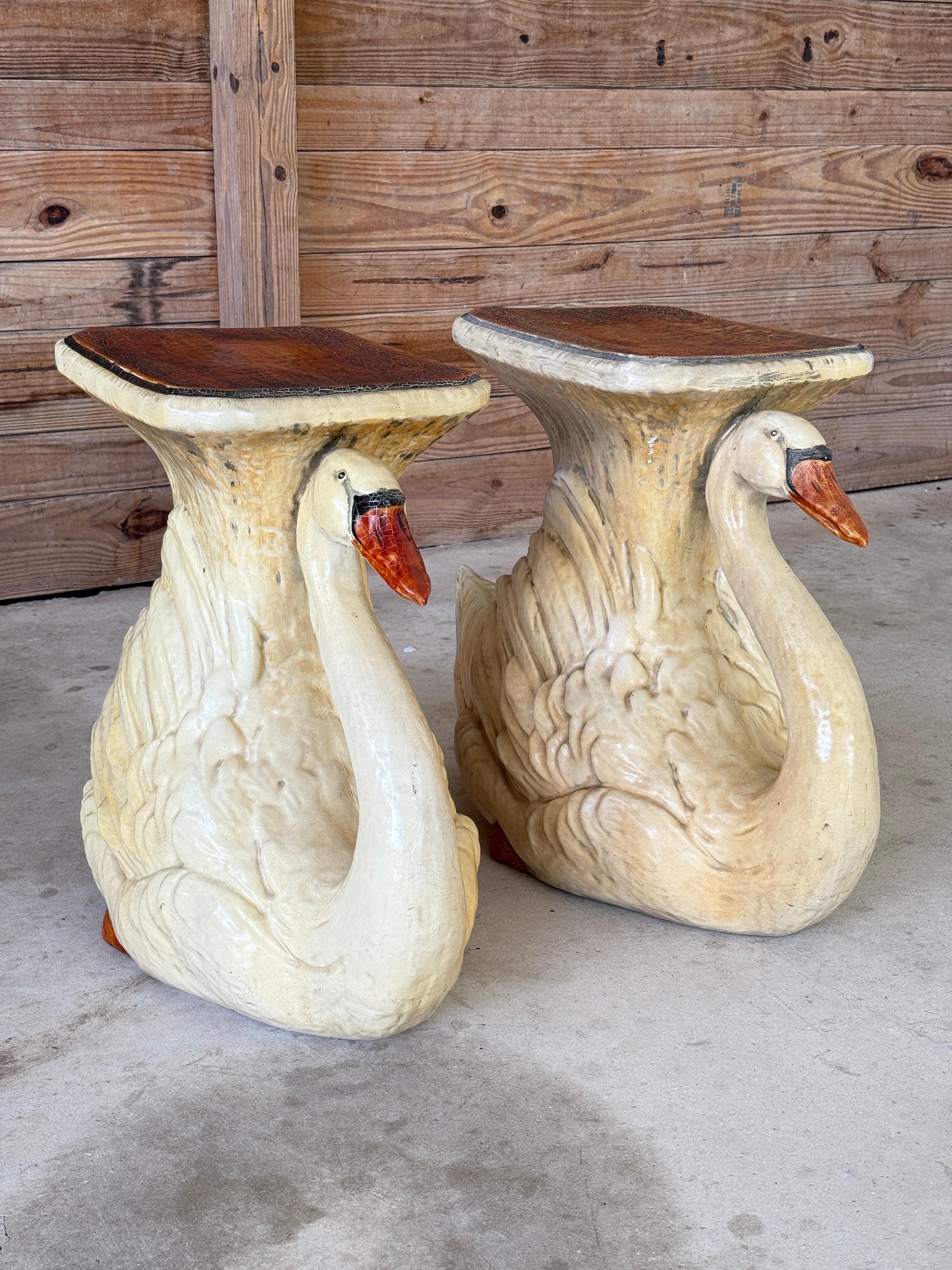 A sculptural and whimsical pair of monumental swan side tables crafted from cast resin with rich hand-finished detailing. These mid-20th century pieces feature graceful swan forms with arched necks and expressive beaks, topped with squared faux