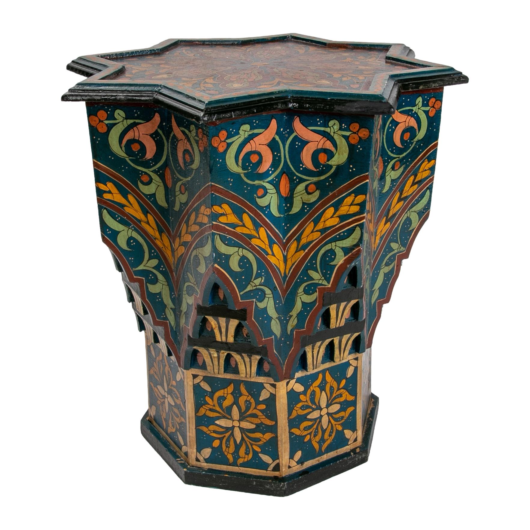 Vintage 1970s Moroccan hand-painted blue 8-point star wooden pedestal table with floral and geometric designs in traditional Mediterranean colours, decorated with moucharabieh fretwork and arches on the base. 

African folk Art handcrafted by