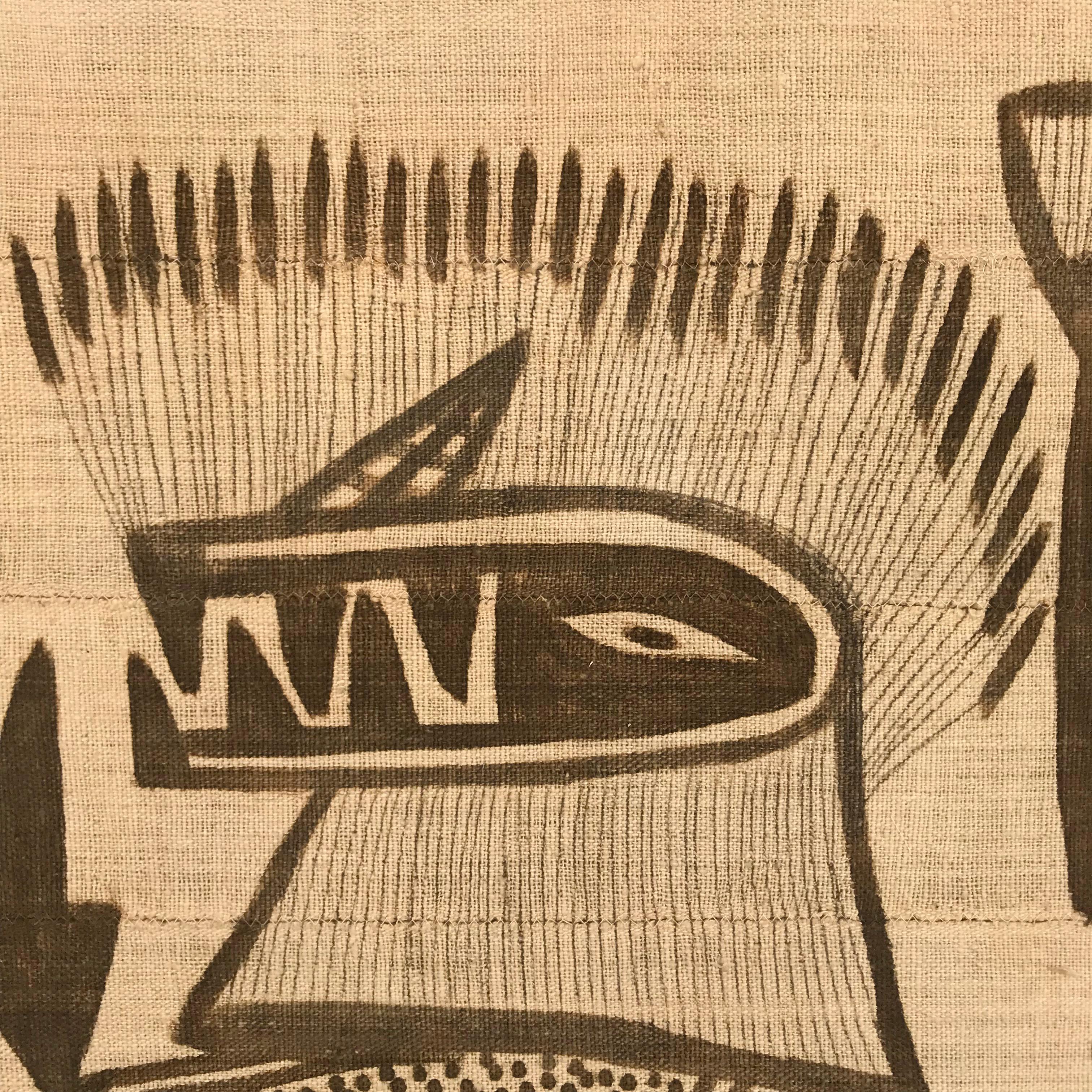 A bold mid-20th century Ivorian Senufo mounted hand-woven cotton Korhogo cloth depicting several figures, some in costume, dancing, amidst a field of birds, deer, and fish. Korhogo cloths are woven of cotton in narrow strips, stitched together, and