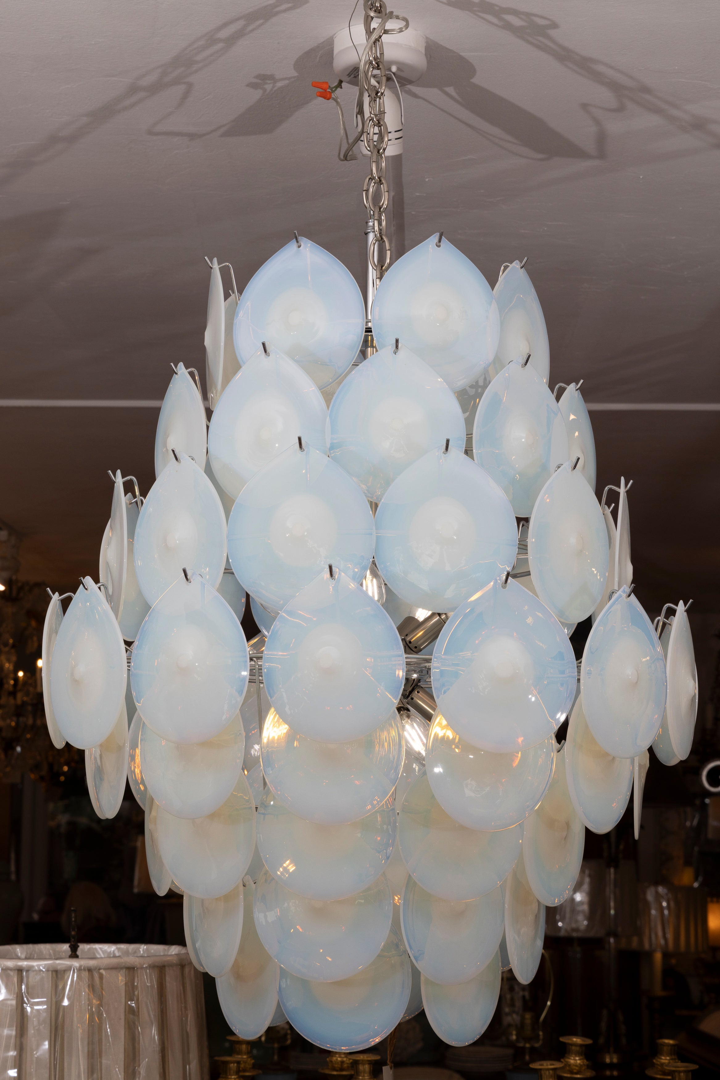 This is a unique mid-century Murano chandelier comprised of a cascade of circular translucent mouth-blown glass disks