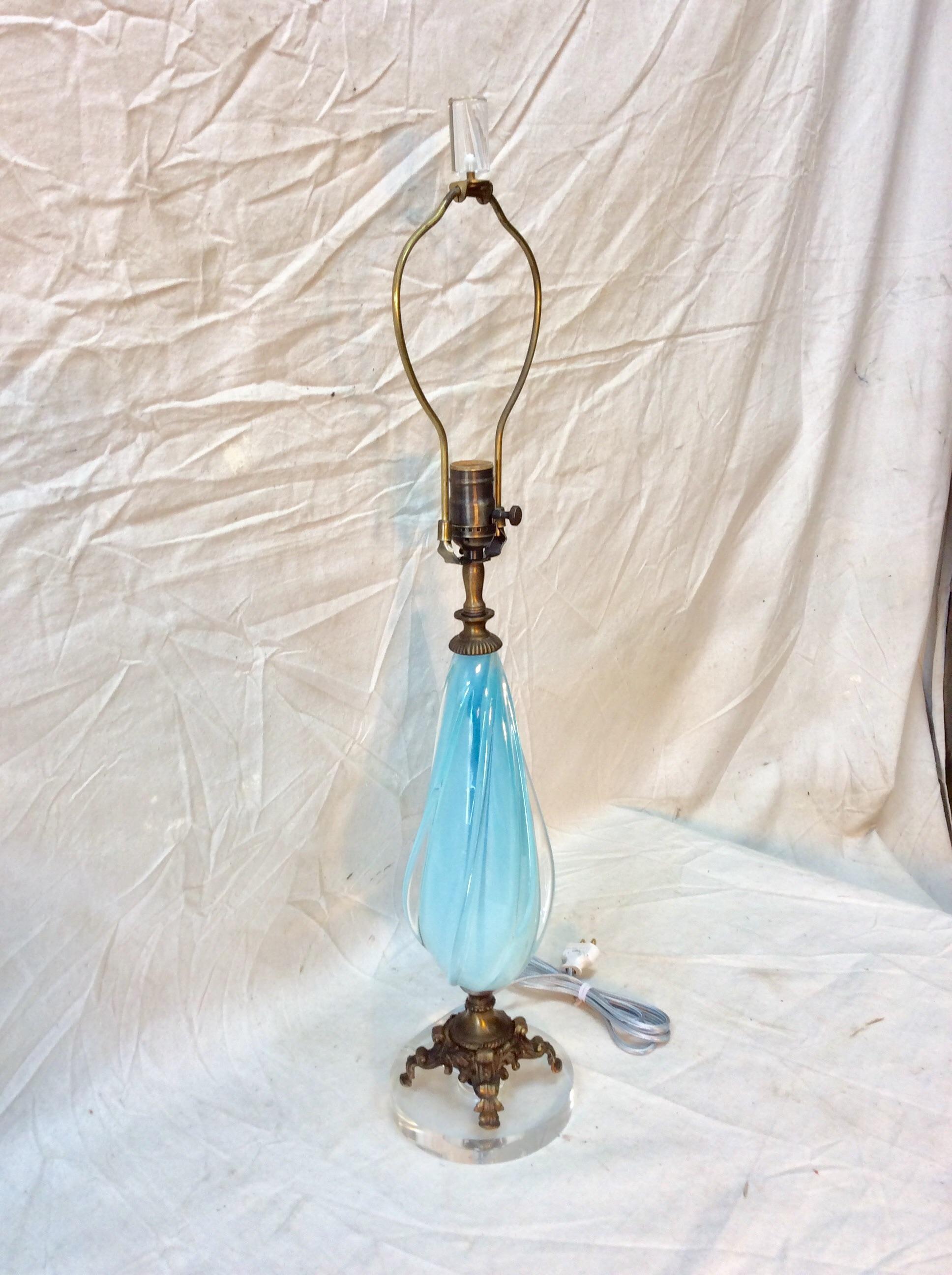 Amazing vintage 1960s Murano glass table lamp. The lamp features a light blue color glass swirl with the original brass base. This lamp have been professionally rewired to USA standards with the addition of a lucite base and finial.


6