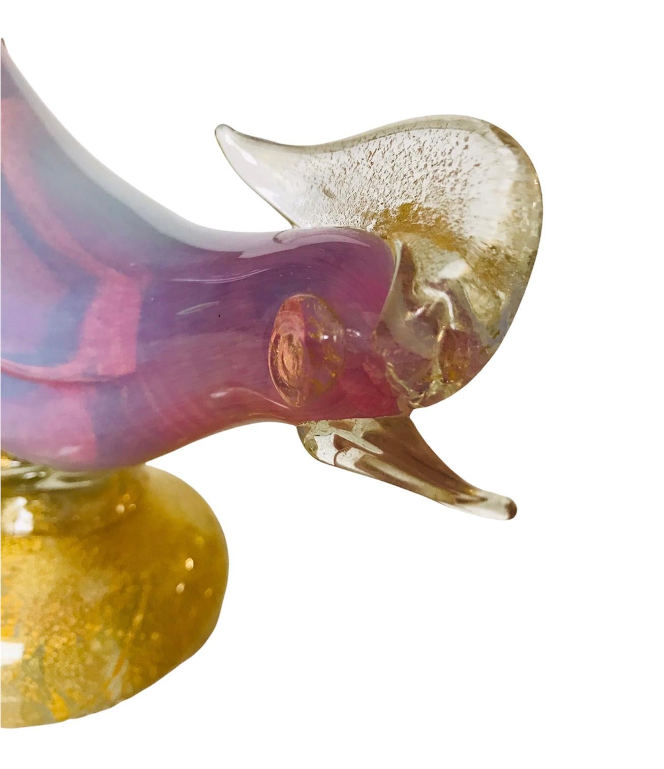 Depending on the refractions of light the 50’s Italian Murano glass pheasant will represent an iridescent shade of light pink or blue. Gold flecks are placed sporadically in the plume, eyes, beak and the base of the figurine. A fine representation