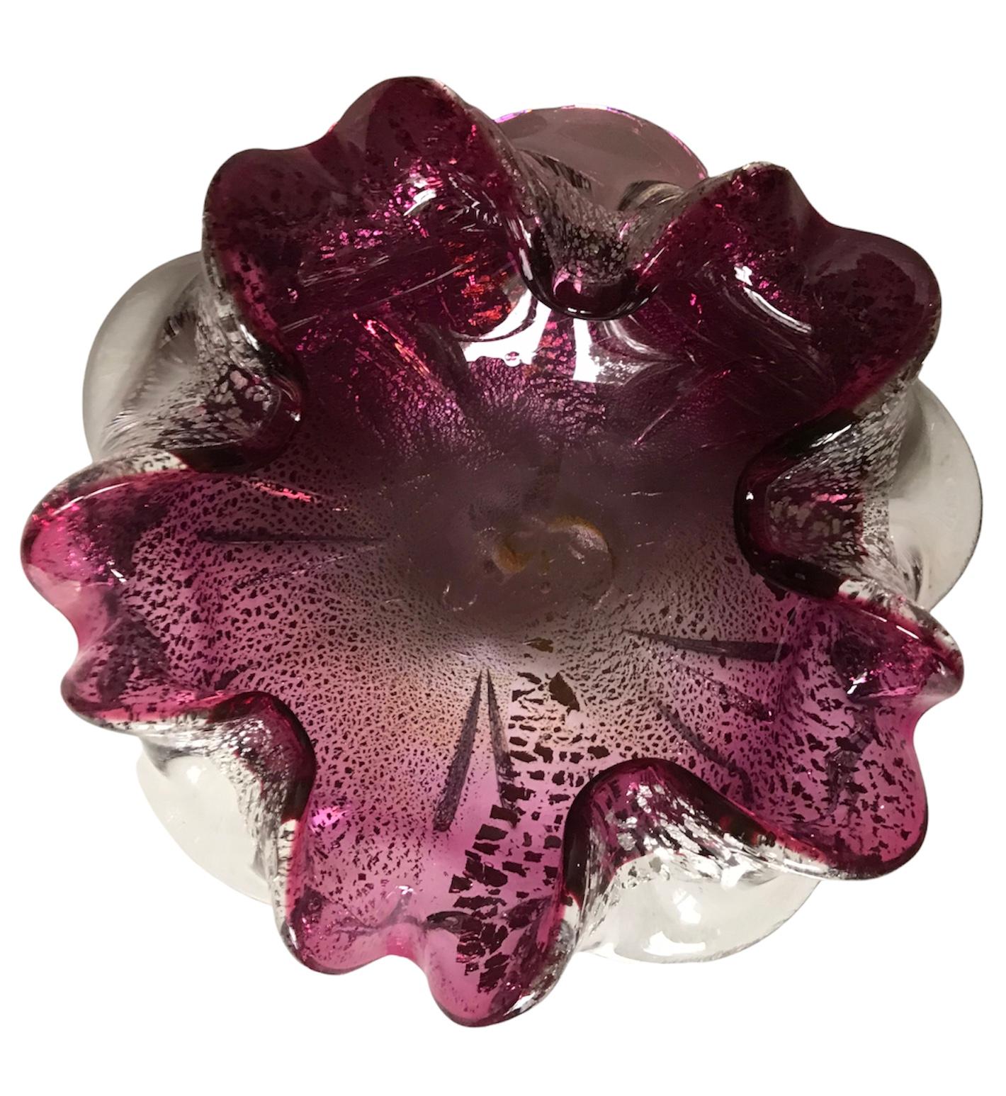 Spectacular representation of an art glass bowl from world renown glass artist/manufacturer Murano (Italy). The bowl has a free flowing ruffle formation with silver and gold specs highlighted from within. An MCM piece of art.