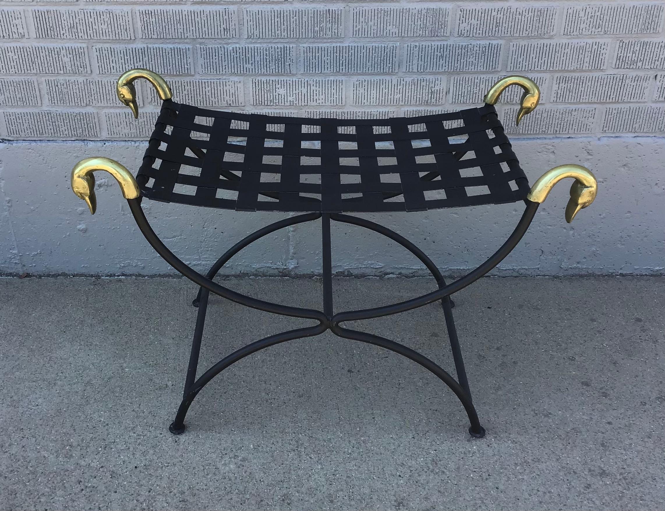 A beautiful French Maison Jansen Attributed Curule stool from the mid 20th Century. This exquisite French stool features a rectangular latticed seat with four elegant brass swan heads and a black metal base. The graceful curule form, rooted in