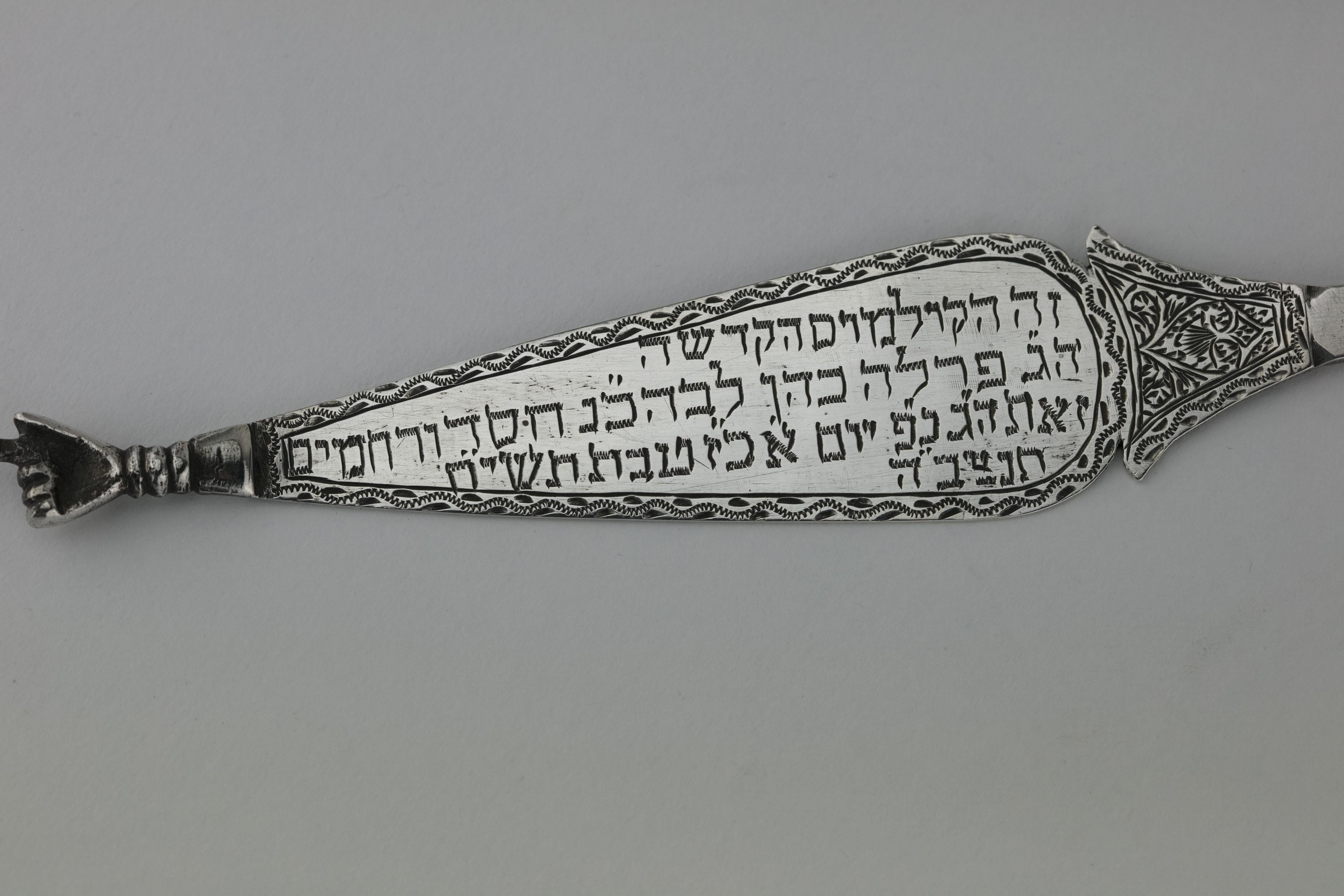 Handmade silver Torah pointer (Yad), North-Africa, 1958.
A flat Torah pointer in the shape of a tree, with a ring in the end.
The pointer is decorated and engraved in Hebrew: 