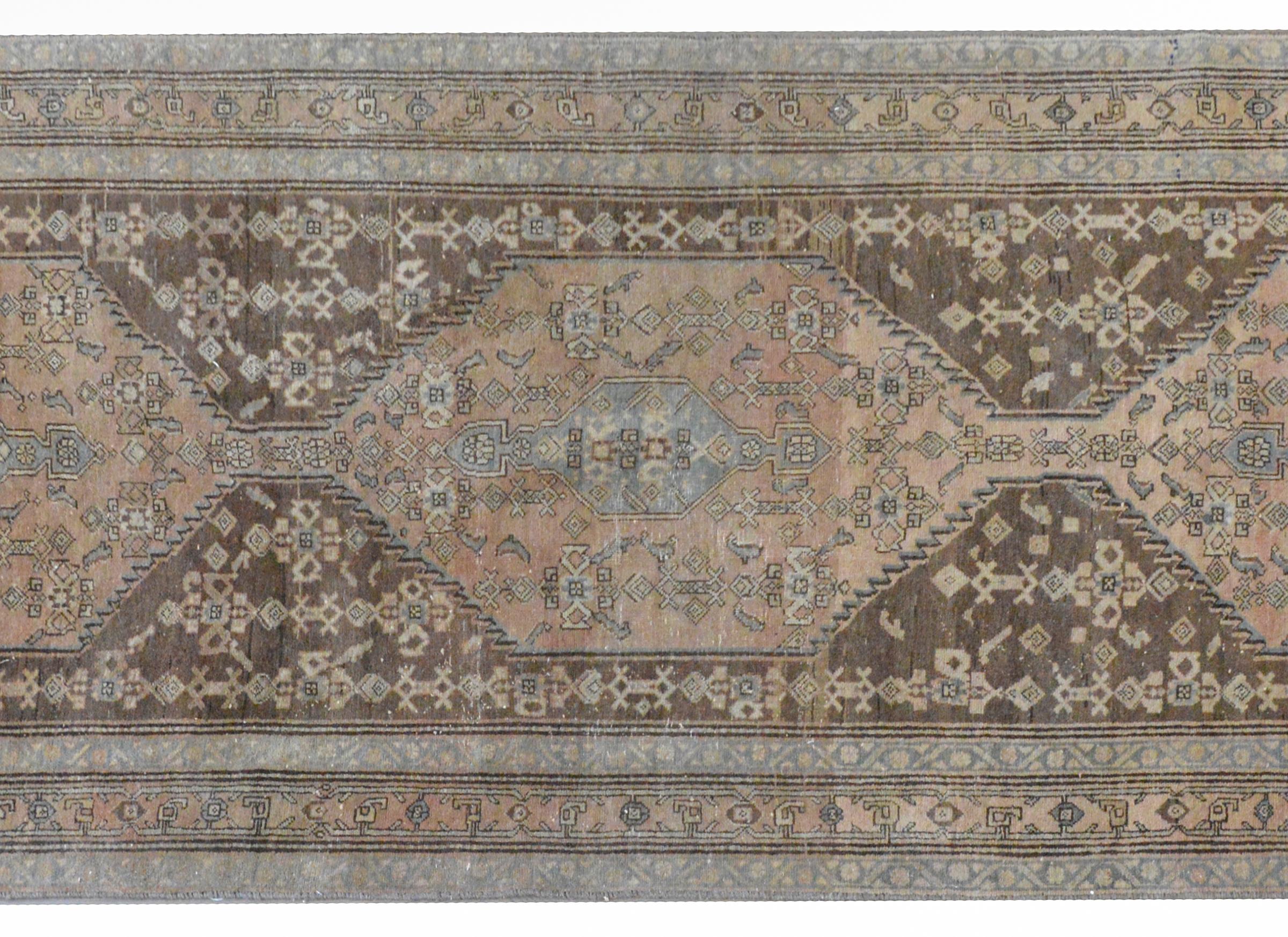 A wonderful mid-20th century Northwest Persian runner with three large medallions woven with stylized floral and vine patterns against an Abrash pale orange field, and surrounded by a pattern of more stylized flowers against a brown ground. This rug