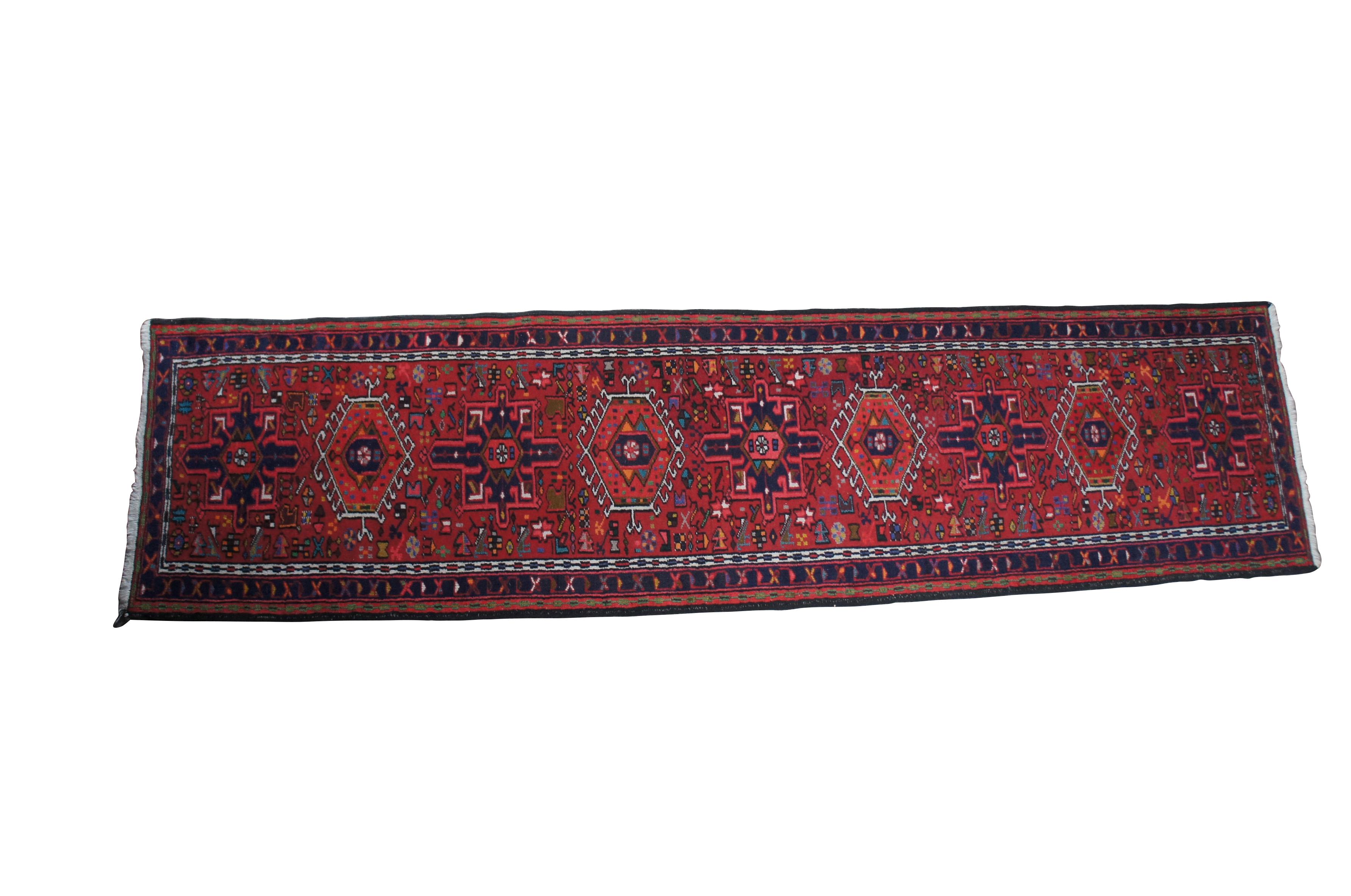 Post WWII NW Persian Vintage rug runner or mat from the Heriz-Karadja villages area, circa 1950-60s.  Features 100% wool pile and geometric designs of blues, purples, orange, browns, grey, beige, green, gold and yellow over a field of red.  Made