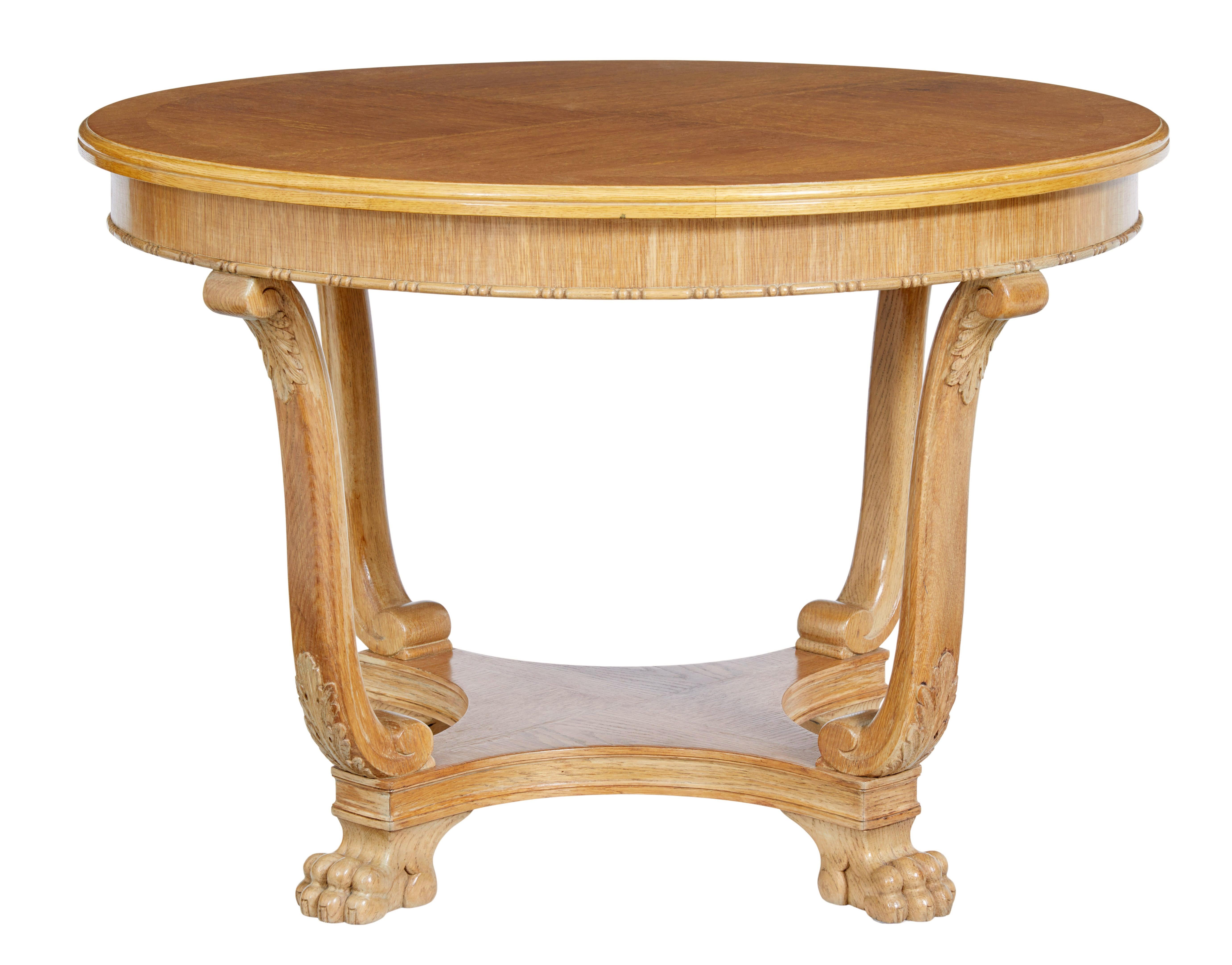 Mid-20th century oak coffee occasional table circa 1940.

Circular top which is quarter veneered and cross banded, with beaded detailing to the freize.  Supported by 4 scrolling legs with carved acanthus leaves. Shaped lower tier which stands on