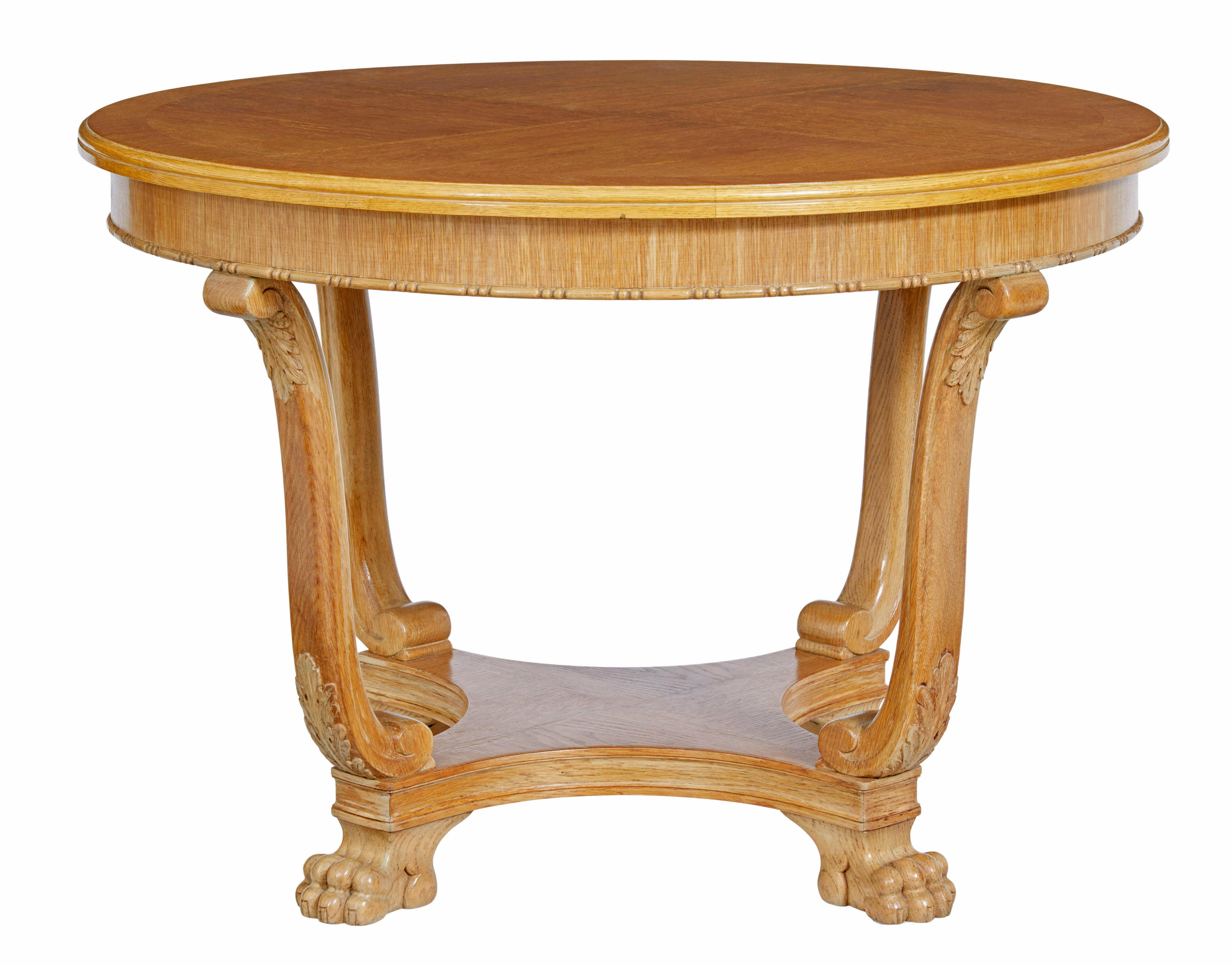 Table d'appoint en chêne du milieu du 20e siècle, circa 1940.

Plateau circulaire plaqué sur quartier et à bandes croisées, avec des détails perlés sur le freize.  Soutenu par 4 pieds à enroulement avec des feuilles d'acanthe sculptées. L'étage