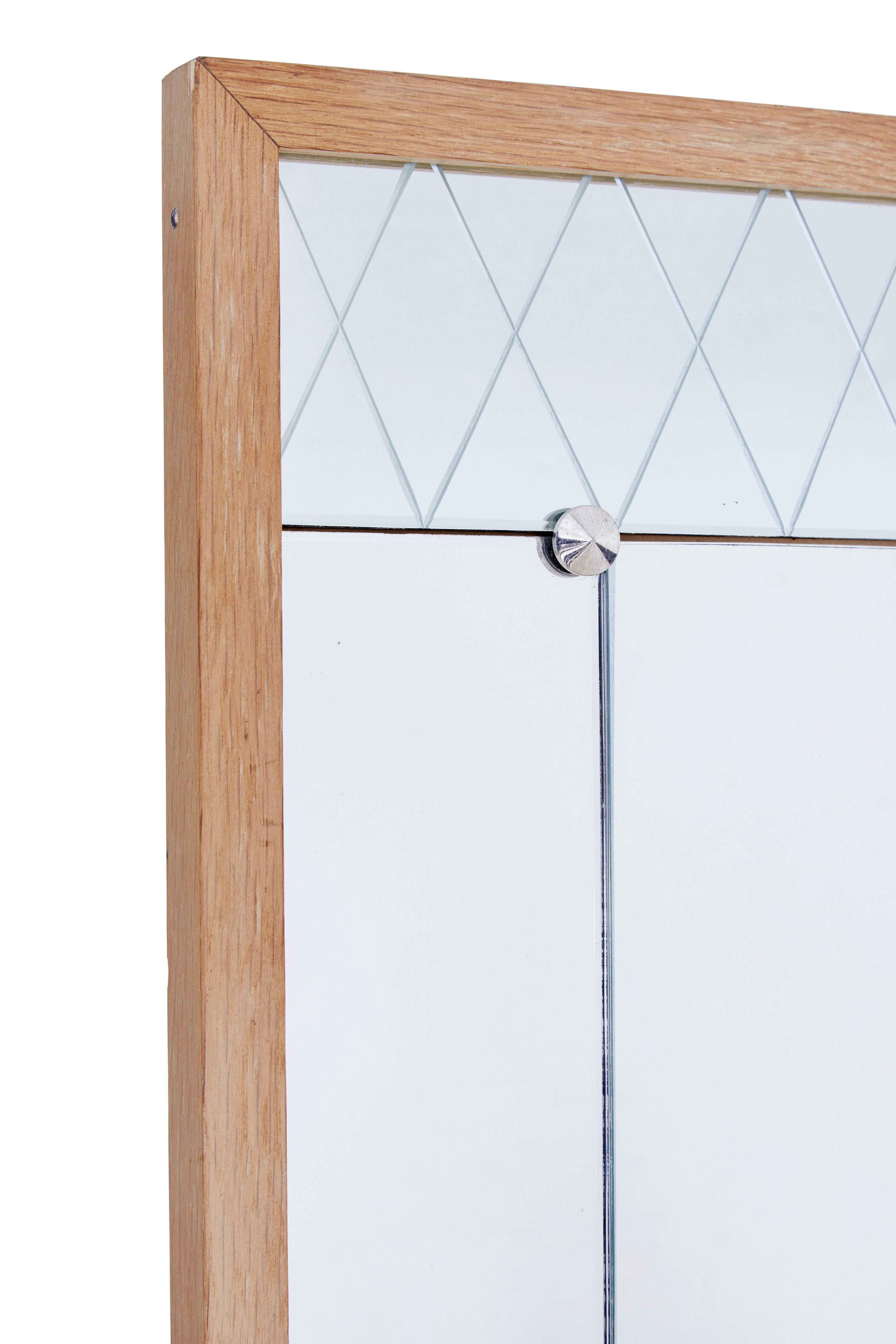 Geätzter Wandspiegel aus Eiche, Mitte 20. Jahrhundert, um 1960.

Spiegel aus schwedischer Produktion, präsentiert in einem hellen Eichenrahmen.  Zentraler, aufrecht stehender Hochformat-Hauptteil des Spiegels mit geätzten Latice-Paneelen oben und