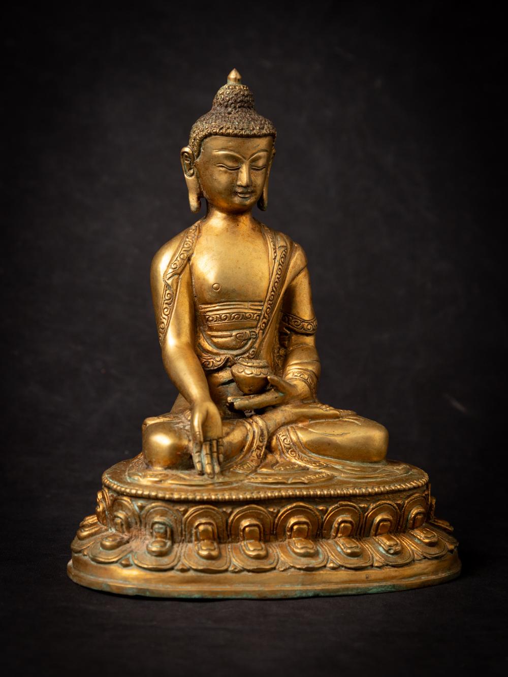 The old bronze Nepali Buddha statue is a remarkable and spiritually significant work of art. Crafted from bronze and adorned with fire gilding in 24-karat gold, this statue stands at a height of 21.6 cm, with measurements of 17.5 cm in width and