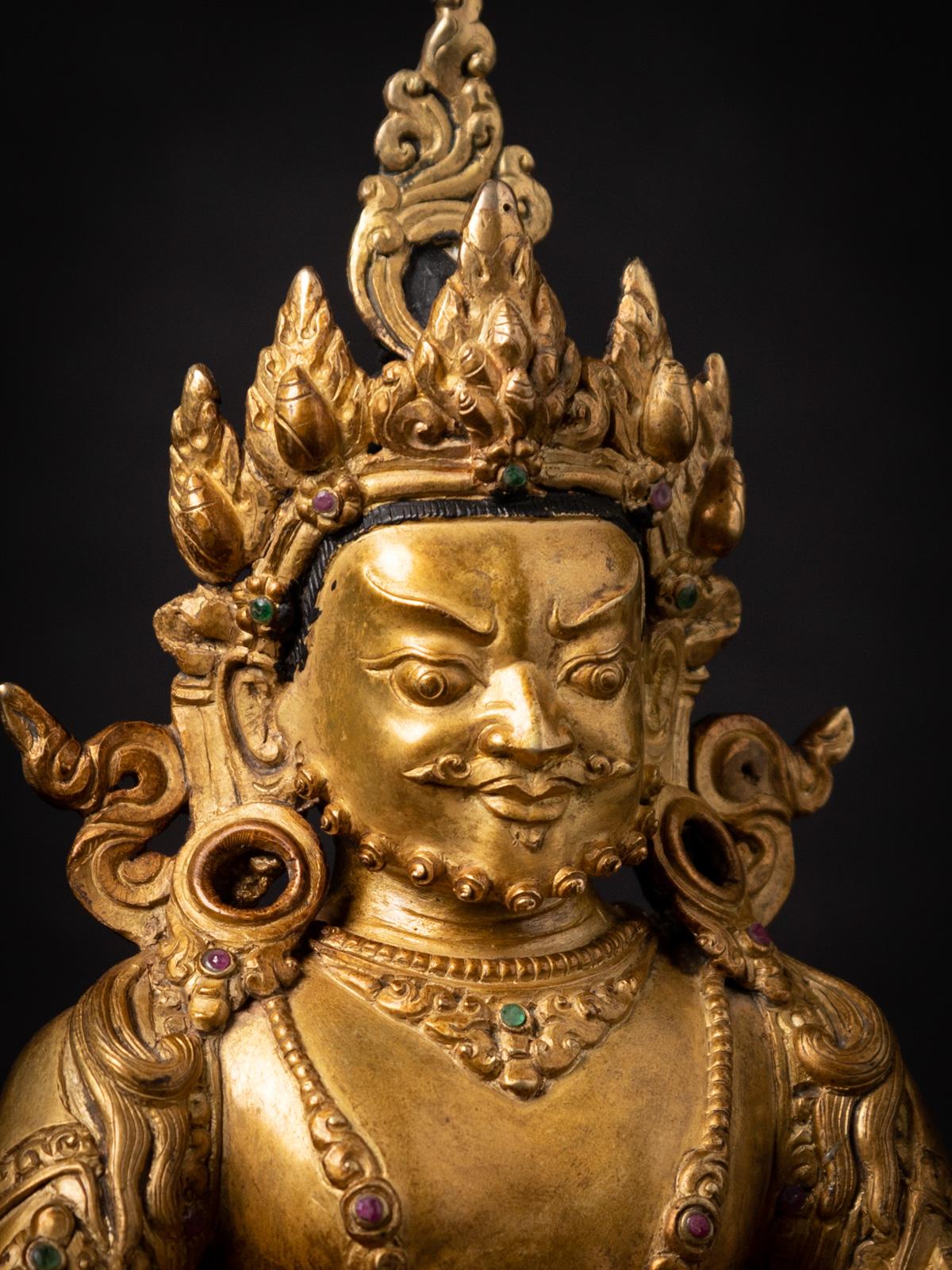 This old bronze Nepali Kuber statue is a remarkable piece of art that reflects the rich cultural and religious traditions of Nepal. Crafted from bronze and fire-gilded with 24-karat gold, this statue stands at a height of 23,3 cm, with dimensions of