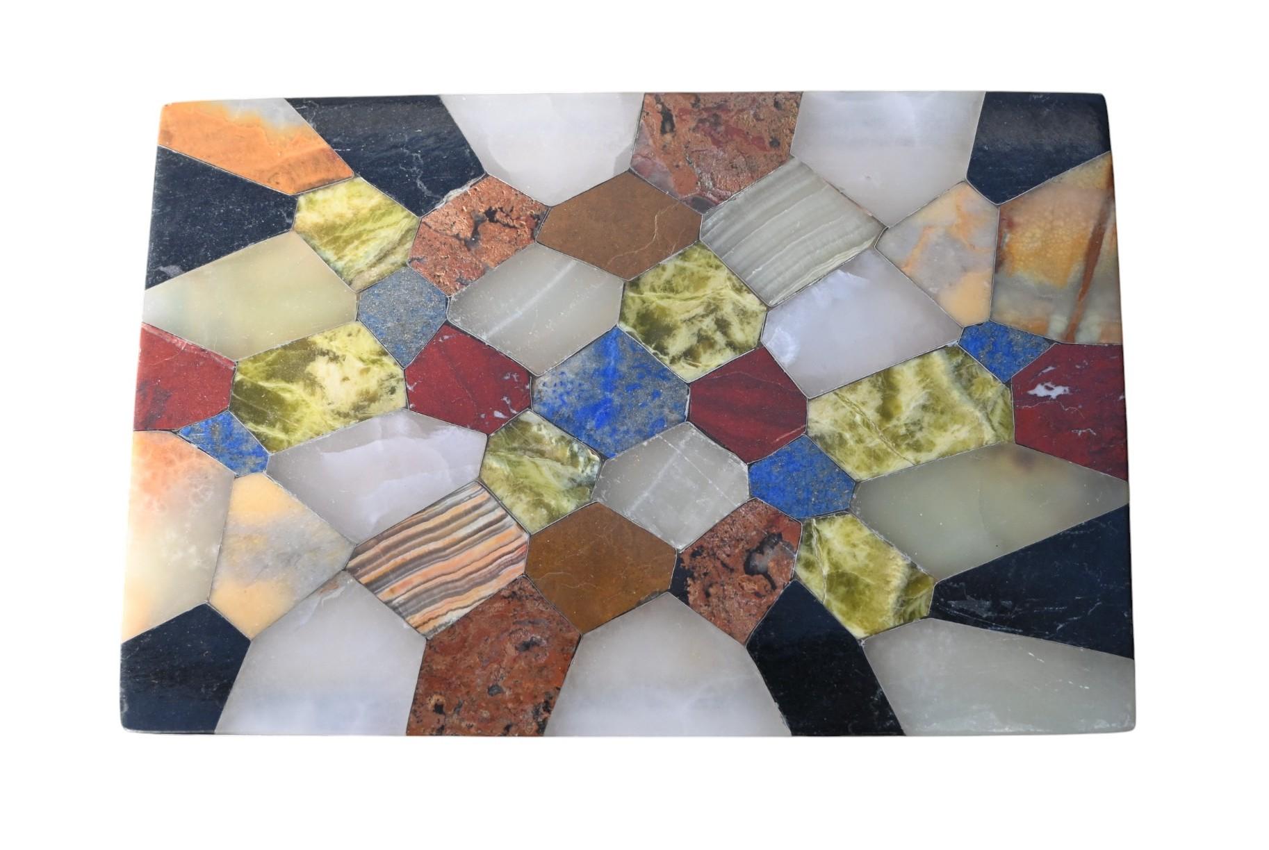 Elegante boîte décorative du milieu du 20e siècle en onyx poli, magnifiquement incrustée de diverses pierres semi-précieuses telles que le lapis-lazuli, le jaspe, le marbre et l'agate. La mosaïque géométrique en pietra dura crée un patchwork vibrant