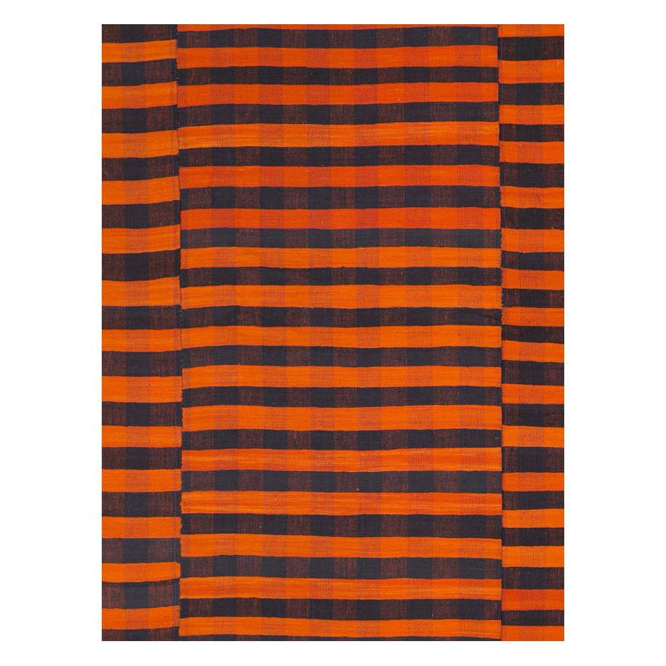 A vintage Turkish flat-weave Kilim room size accent rug handmade during the mid-20th century with a striped design in orange, black and dark blue.

Measures: 6' 11
