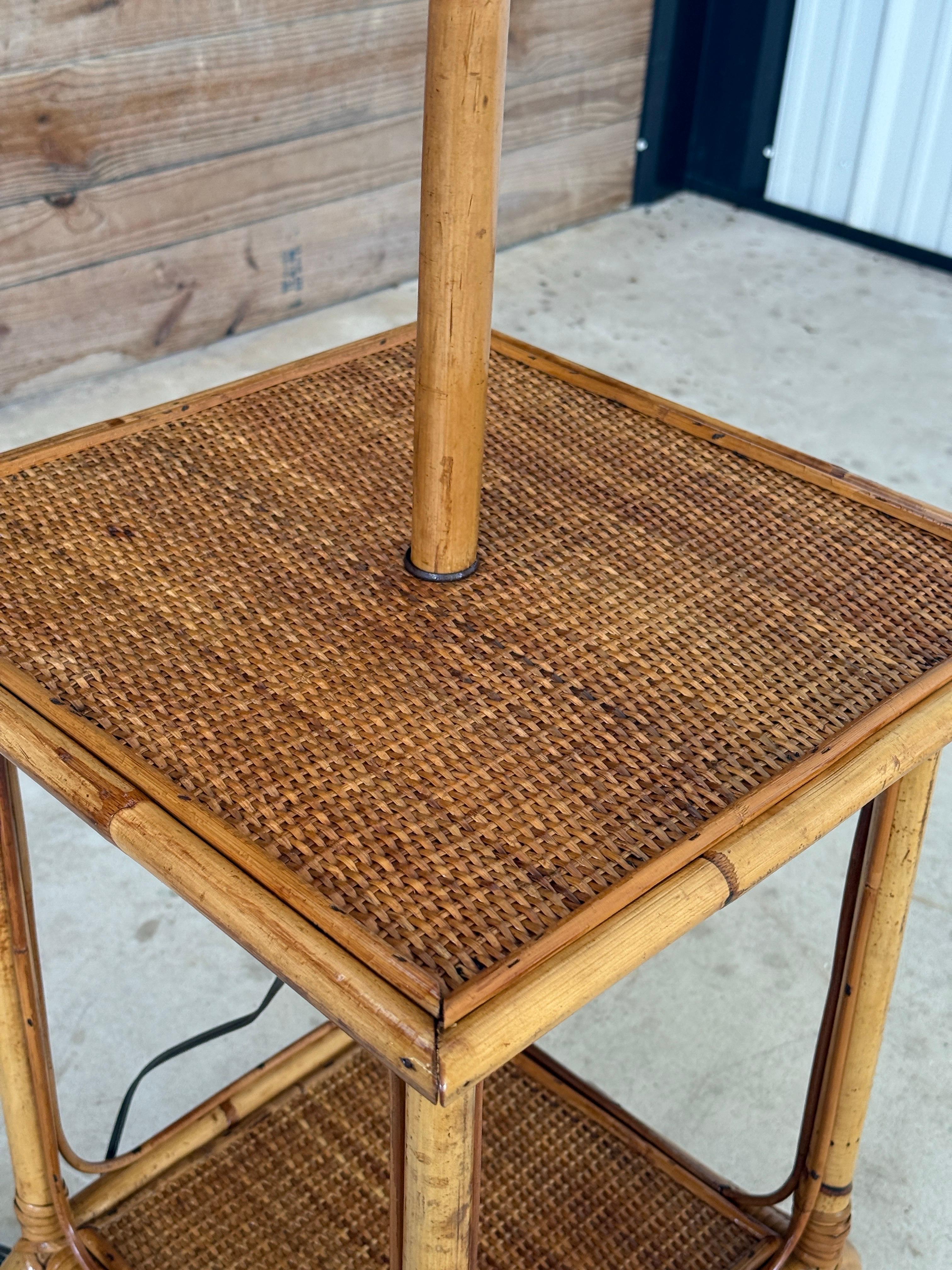 Exemple raffiné du modernisme tropical du milieu du XXe siècle, ce lampadaire sculptural en bambou et en rotin est doté d'une table intégrée à deux niveaux avec une surface en rotin tressé et de gracieux détails en rotin courbé.
Restaurée avec soin,