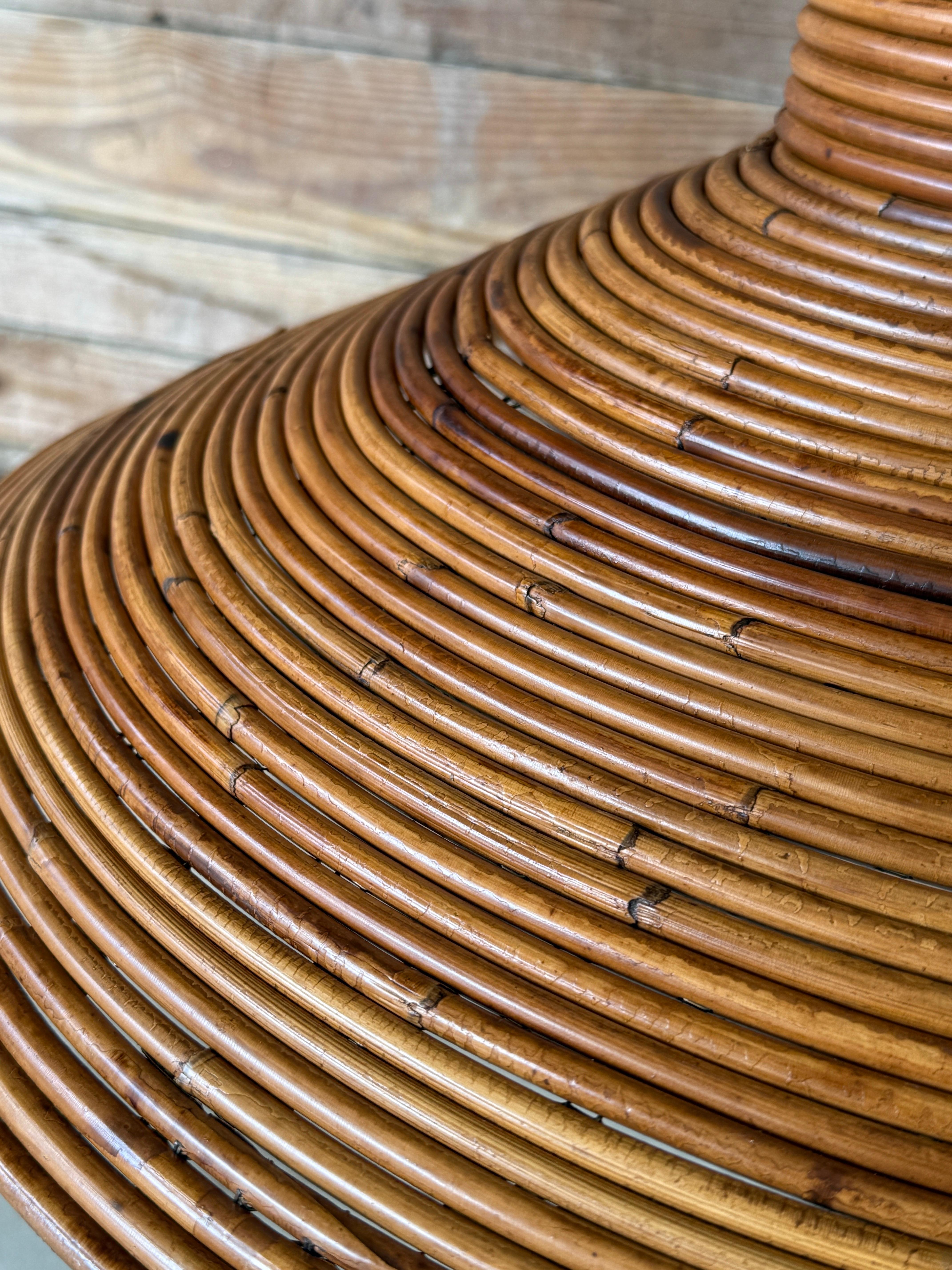 A striking mid-century pencil reed rattan pendant chandelier exudes organic modern charm with its intricately woven texture and sculptural form. Designed with a wide, tapered silhouette, this unique fixture casts a warm, diffused glow that instantly