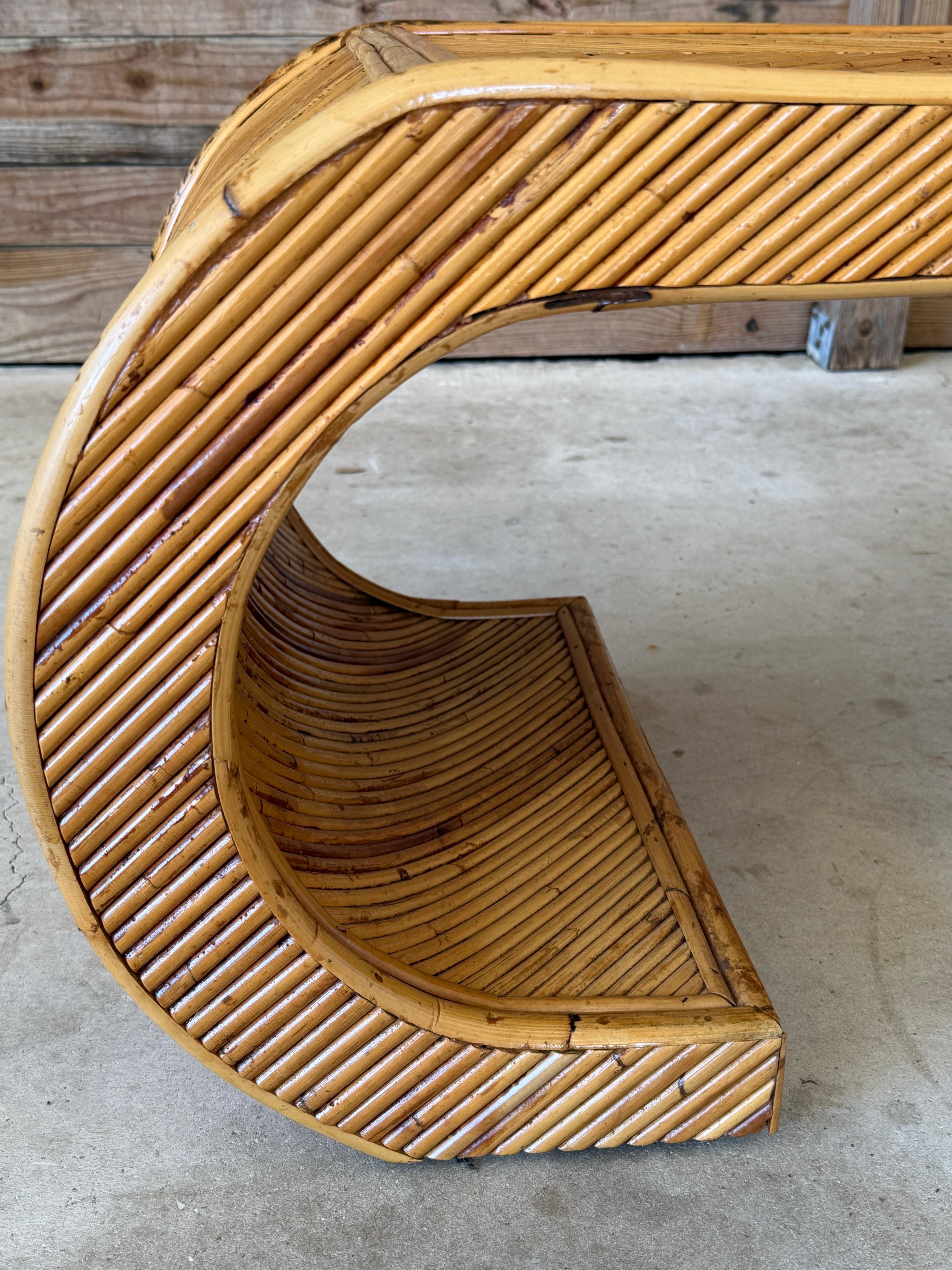 A beautifully restored Mid-20th Century rattan waterfall scroll coffee table, showcasing a sculptural silhouette with curved sides and a striking geometric rattan pattern on the tabletop. This iconic organic modern design exudes timeless coastal