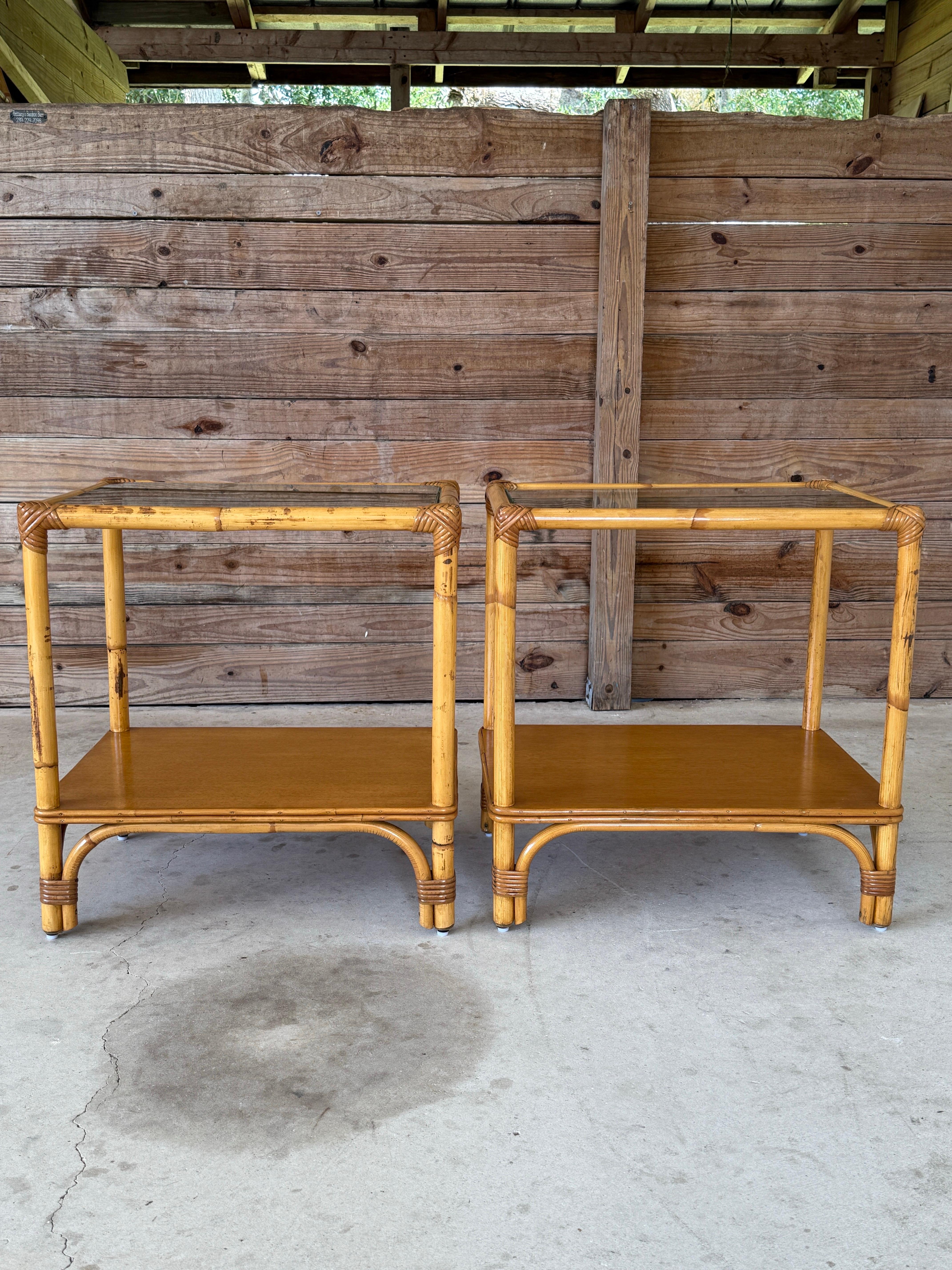 Cette paire de tables d'appoint en rotin du milieu du 20e siècle allie un design côtier classique à un savoir-faire intemporel. Magnifiquement restaurée et remise à neuf, chacune d'entre elles présente un ton miel chaud avec des reliures en rotin