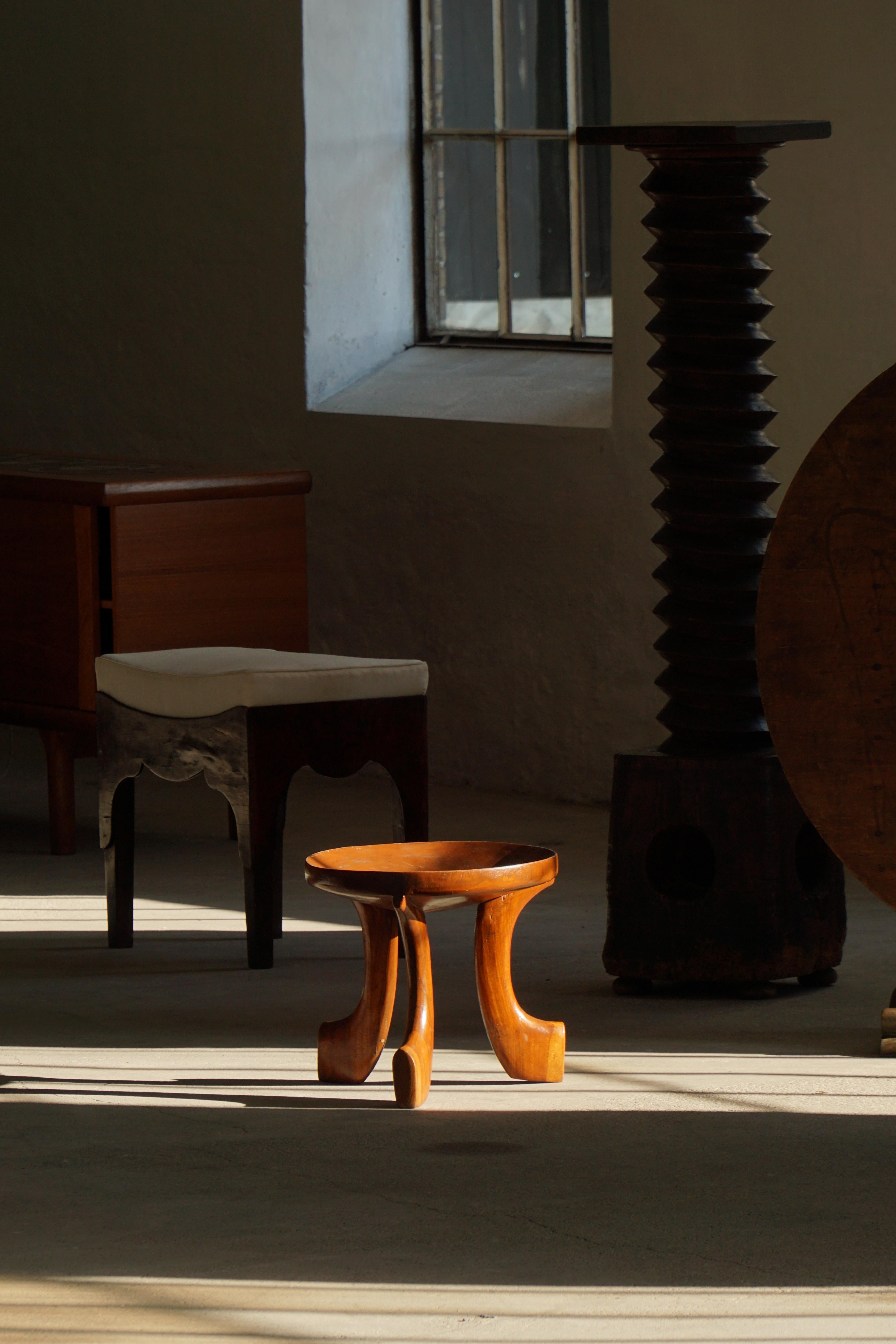 Un bello taburete artesanal oromo de Etiopía, de mediados del siglo XX. Tallado a mano en madera maciza, este taburete muestra las líneas limpias y escultóricas características del diseño oromo, combinando funcionalidad y expresión artística. Su