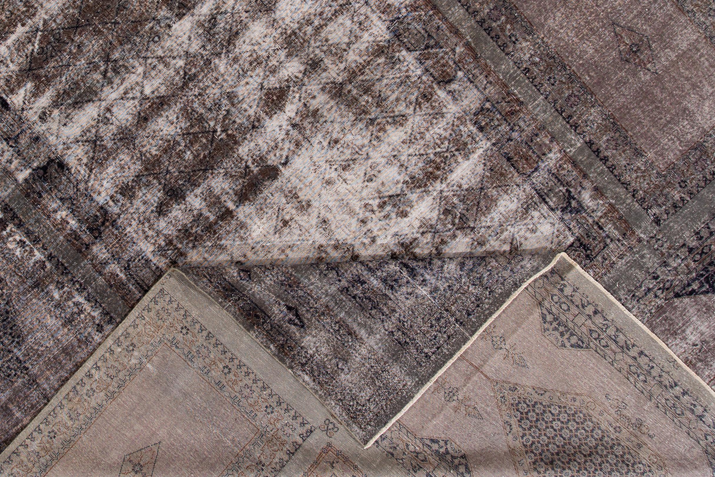 Beautiful vintage oversize distressed rug, hand knotted wool with a, overdyed gray field.
This oversize piece measures: 11'5