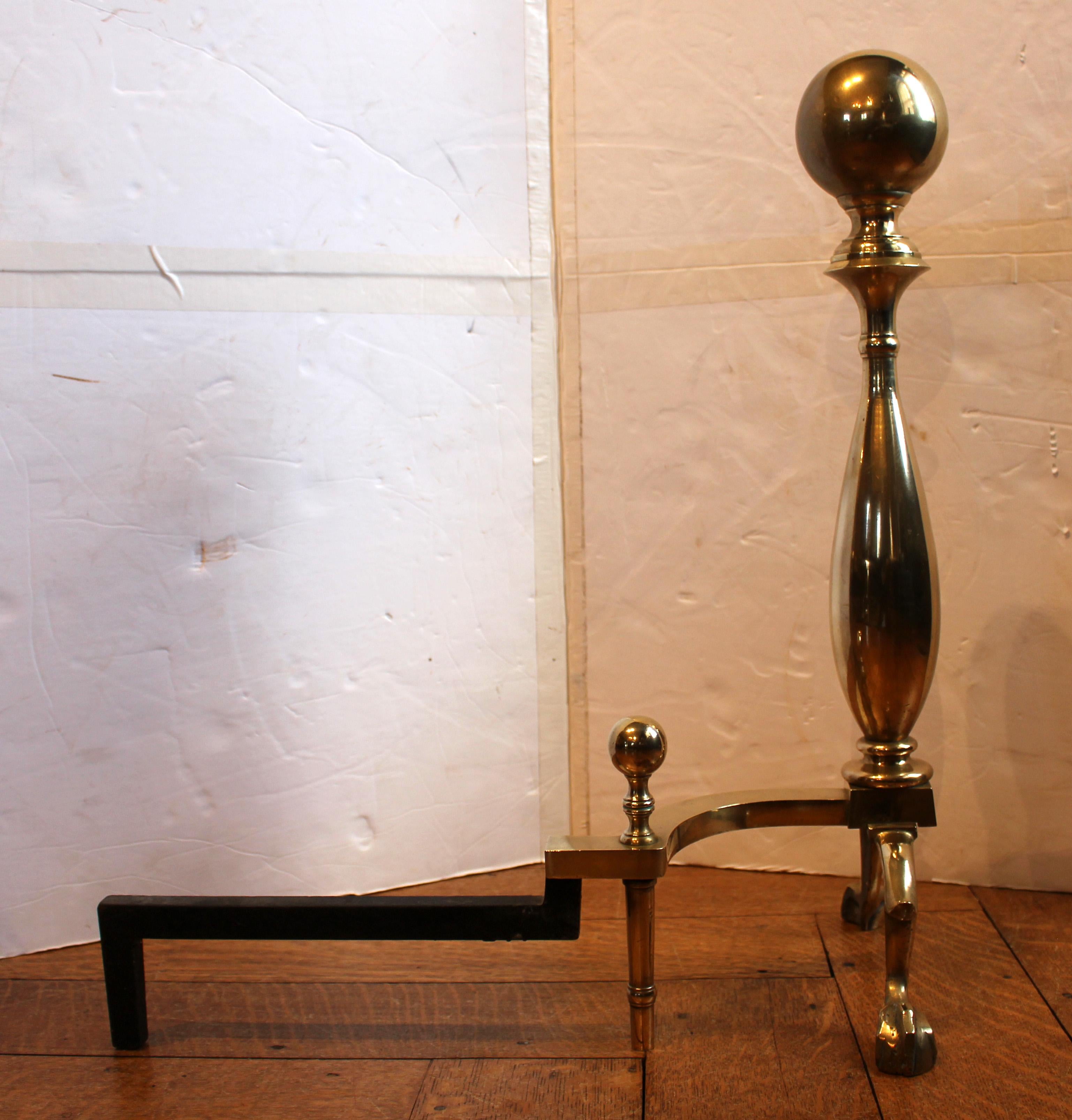 Mid-20th century pair of brass andirons, American. Very heavy, fine quality with ball tops & conforming ball top log stops with spurred ball & claw feet in the Colonial Revival style. Marked 112-1/2 & Made in USA in the log rests.
24.5