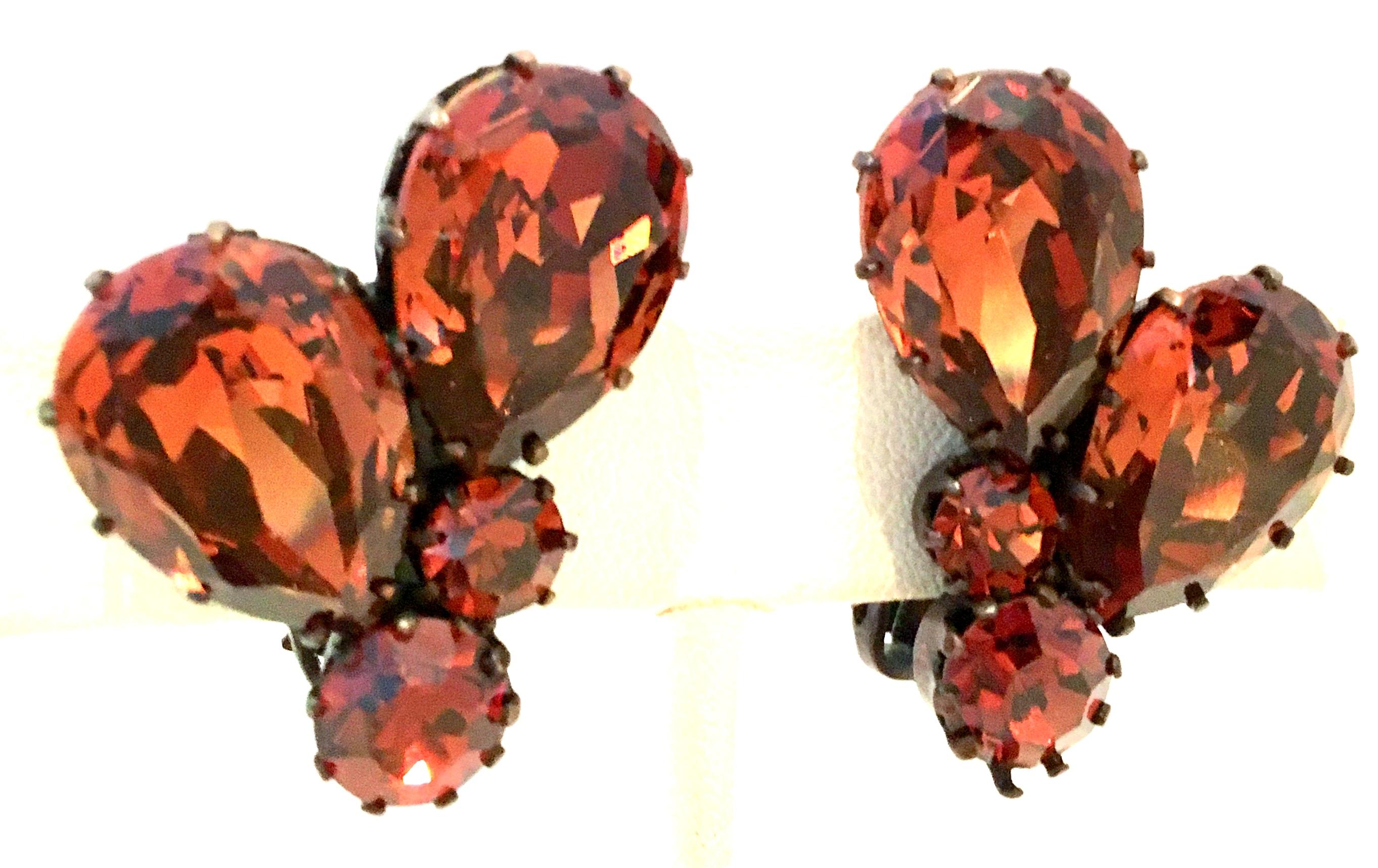 Mid-20th Century Pair Of Austrian Crystal Earrings-Signed. This Right/Left designed pair of earrings features deep amber brilliant cut and faceted stones set in fancy prong antiqued bronzed plate metal.
Each clip style earring is signed, Made In