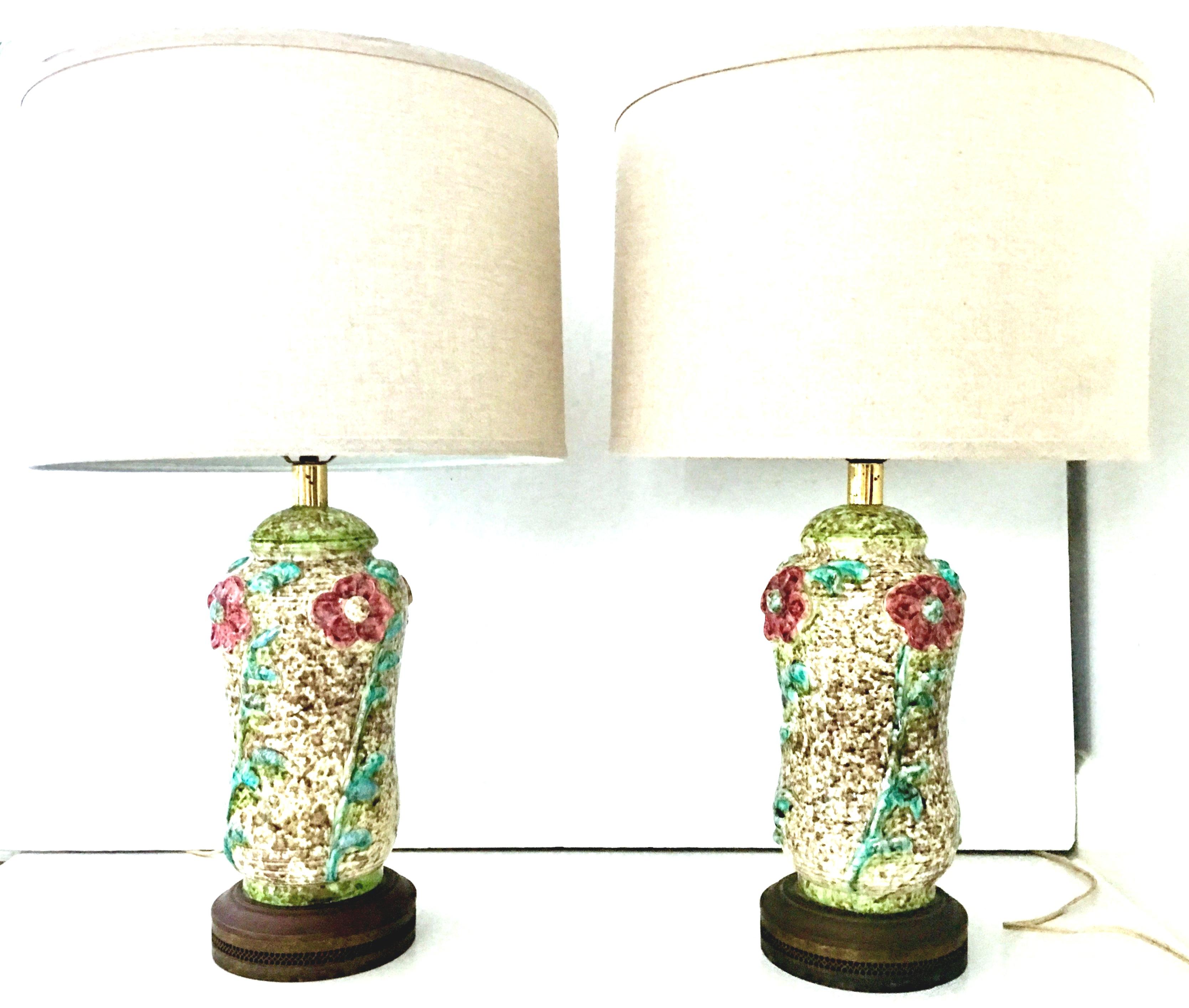 Mid-20th Century Art Nouveau pair of ceramic glaze and gilt brass floral motif table lamps. These most unique handmade lamps feature a white and wheat ground with textured, raised and incredibly executed floral motif in red, pink, green and