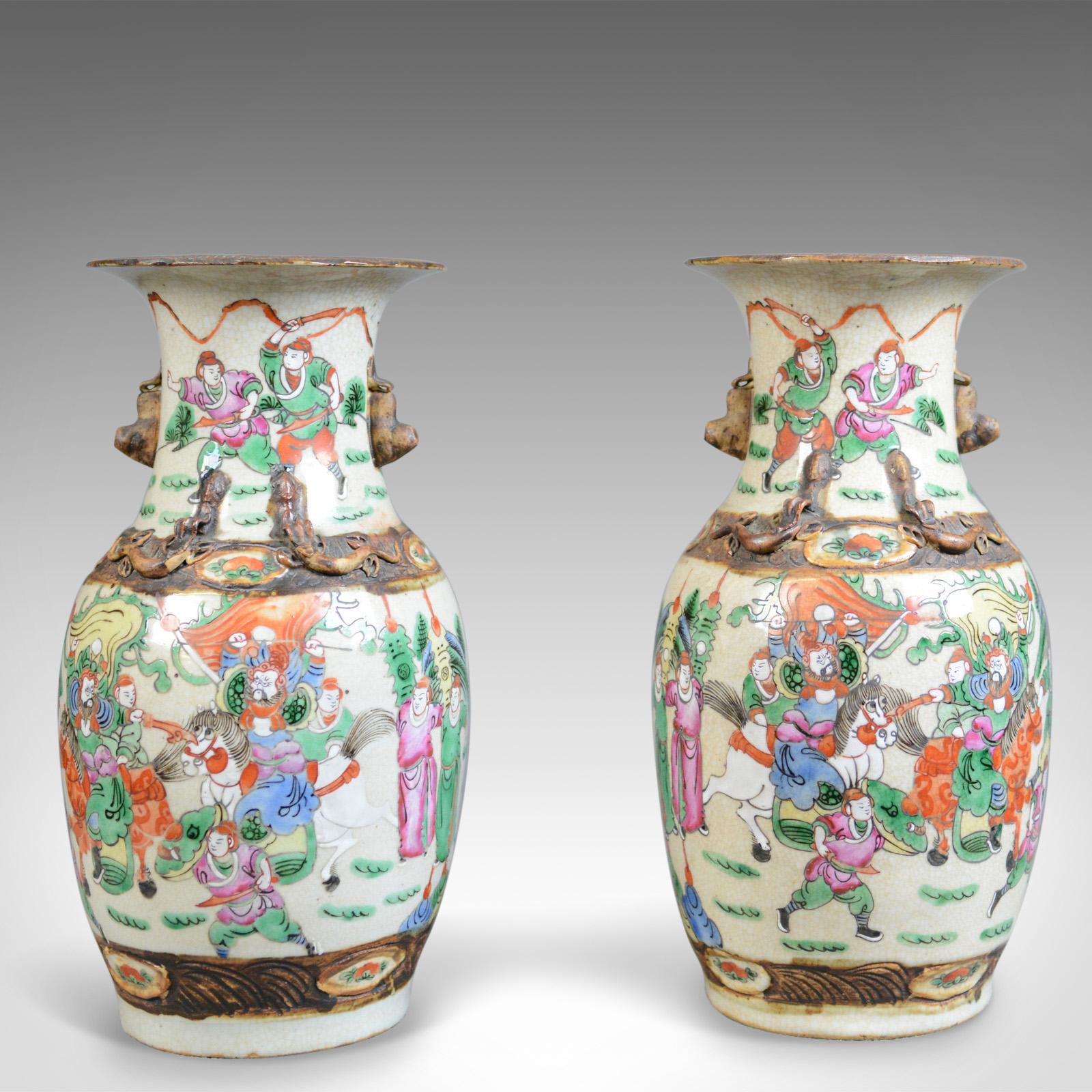 This is a midcentury pair of Chinese baluster vases, painted ceramic urns. 

Imposing quality pair of ceramic vases 
Profusely decorated in on a cream ground
Free from any damage or marks
Busy scenes of figures and horses in a pastel